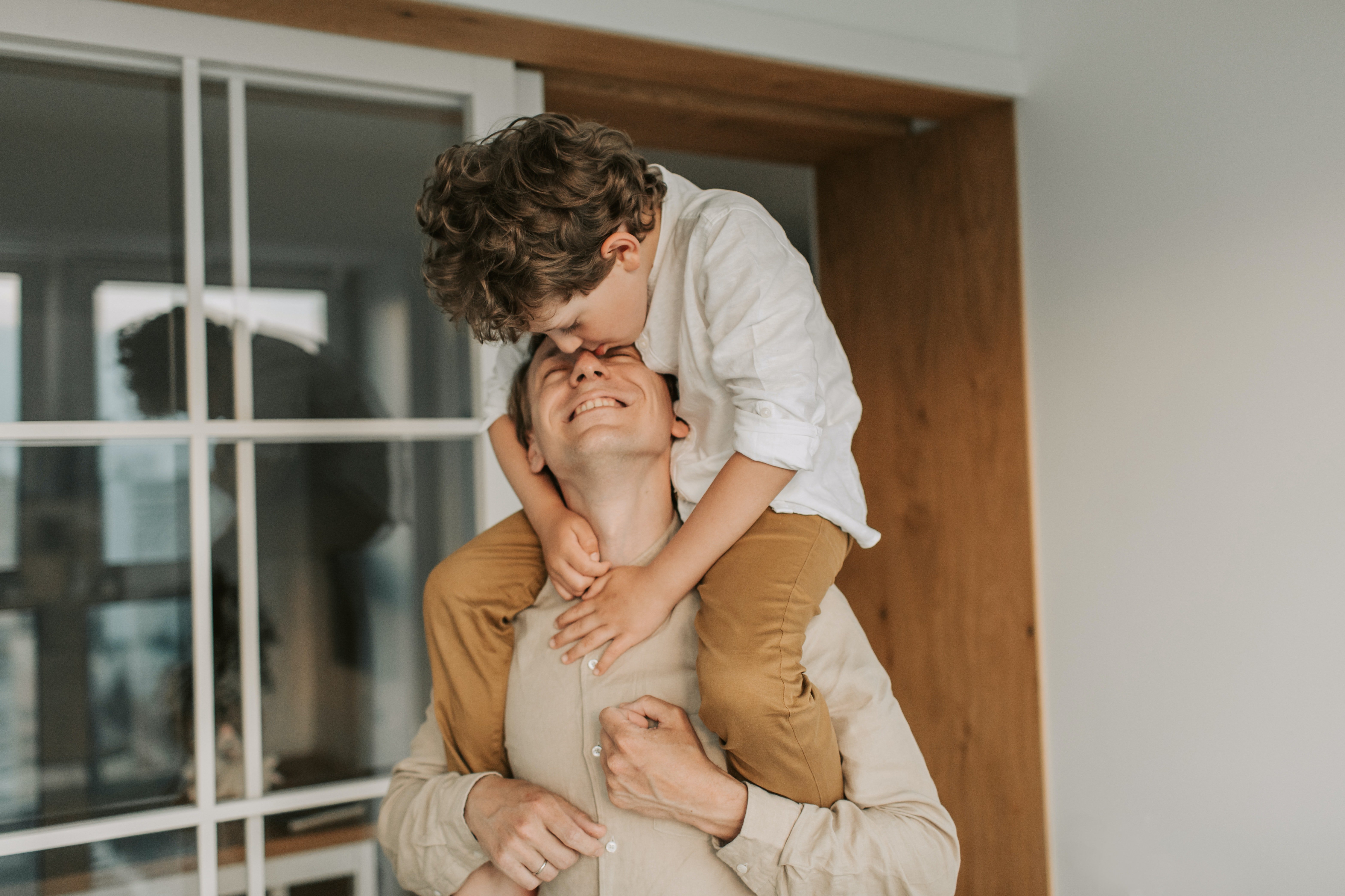 Pictured - A man carrying his son on his shoulders wearing coordinated outfits | Source: Pexels 