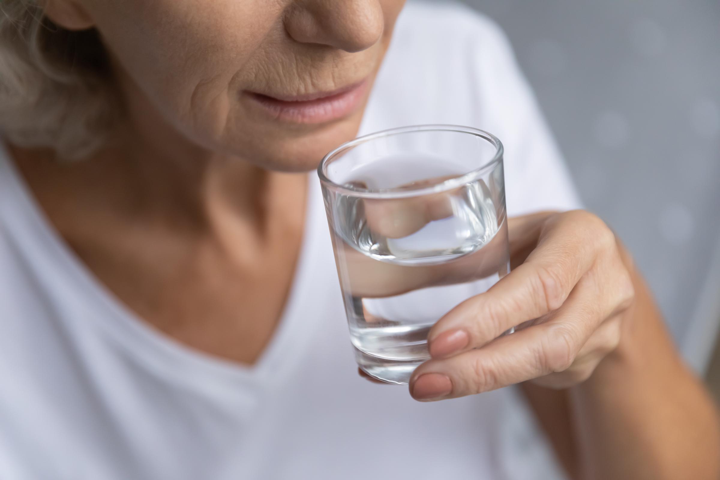 Woman drinking a glass of water | Source: Shutterstock