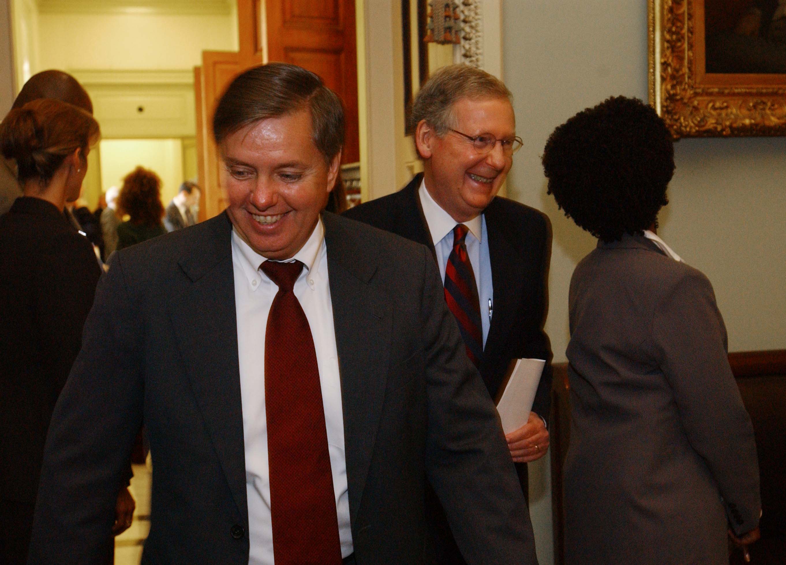 Lindsey Graham shares a laugh with Senate Republican leader Mitch McConnell as the two leave a policy luncheon on Capitol Hill. The candid moment captures a lighter side of the veteran senator amid the daily pace of congressional life. | Source: Getty Images