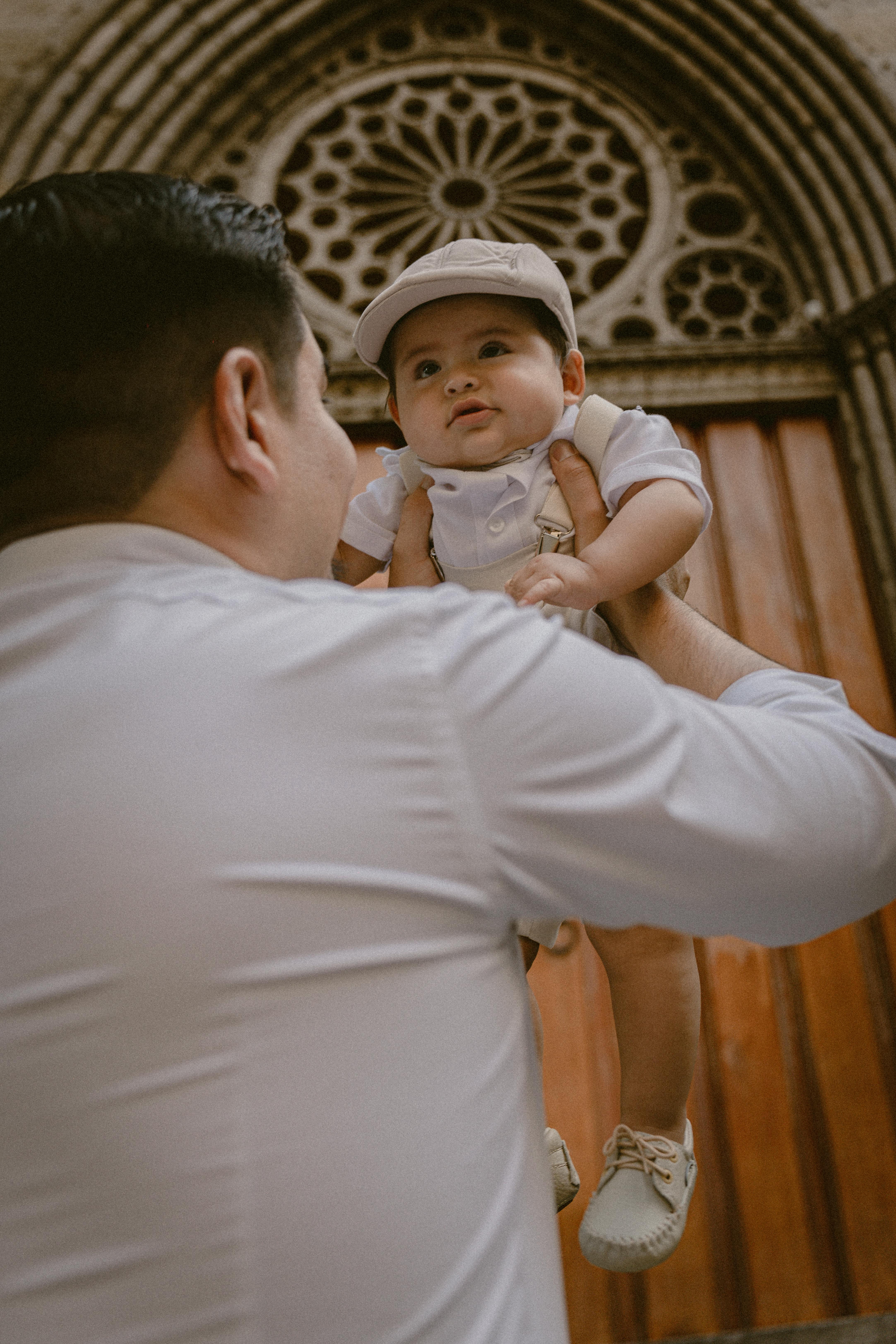 A man holding up a baby | Source: Pexels