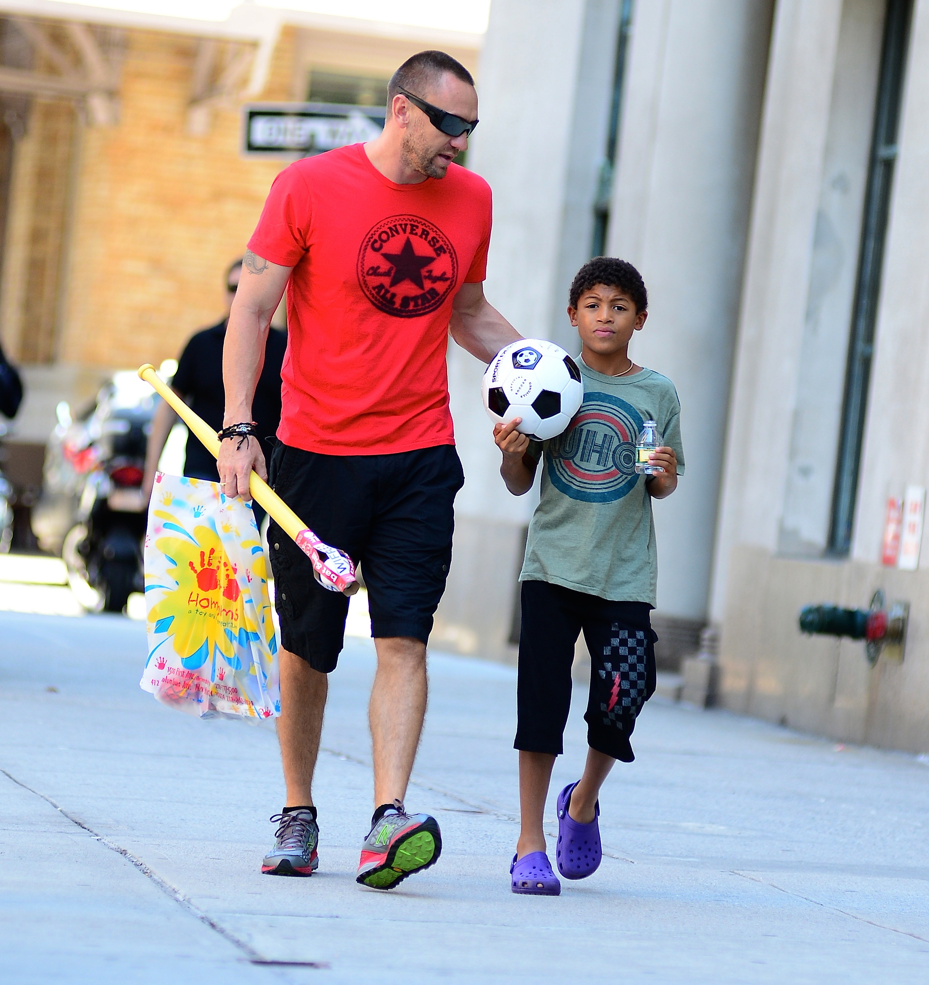 Walking side by side through Tribeca, Martin Kirsten chats casually while Henry Gunther Ademola Dashtu Samuel carries a soccer ball and drink.