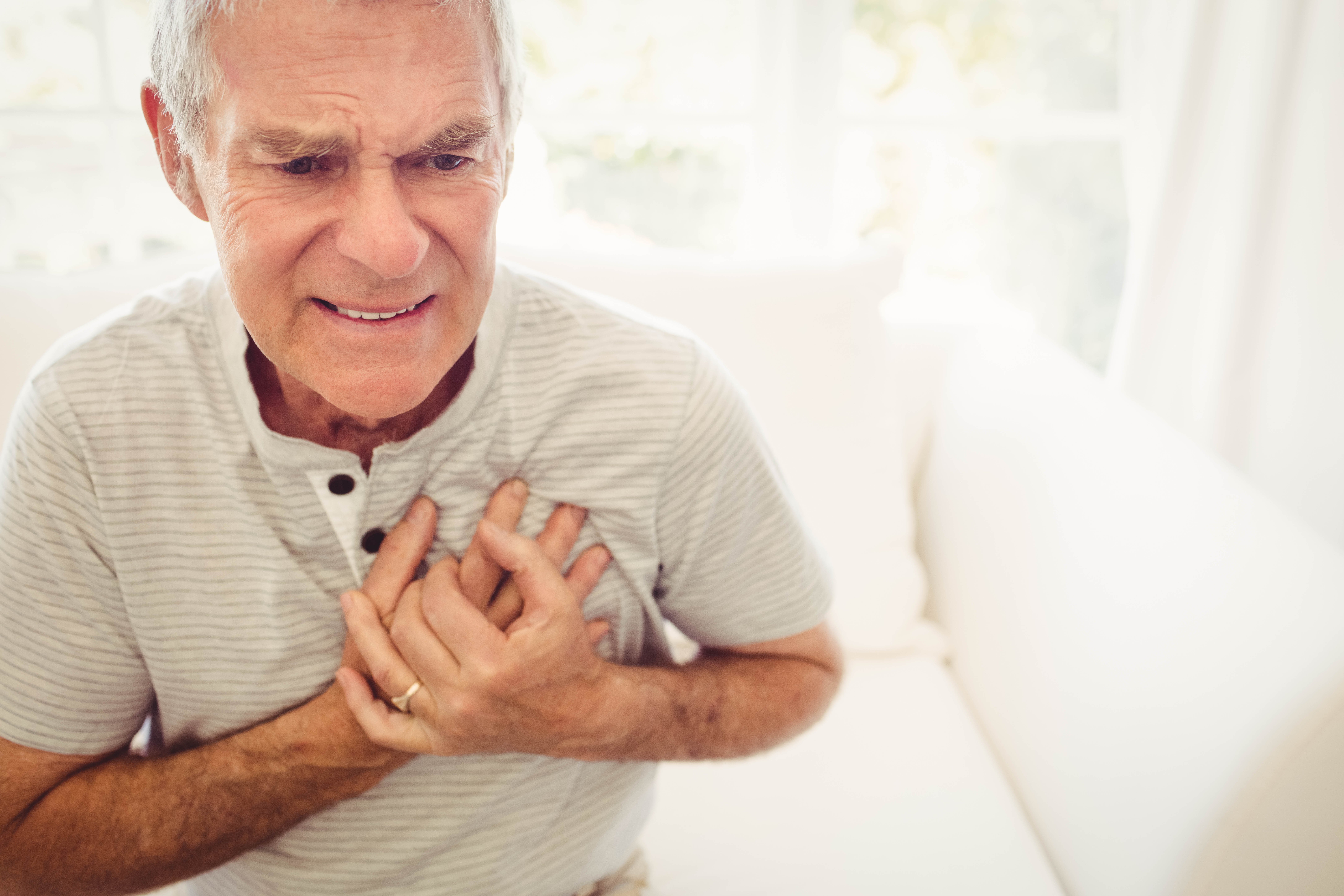 Senior man with pain in the heart in bedroom | Photo: Shutterstock.com
