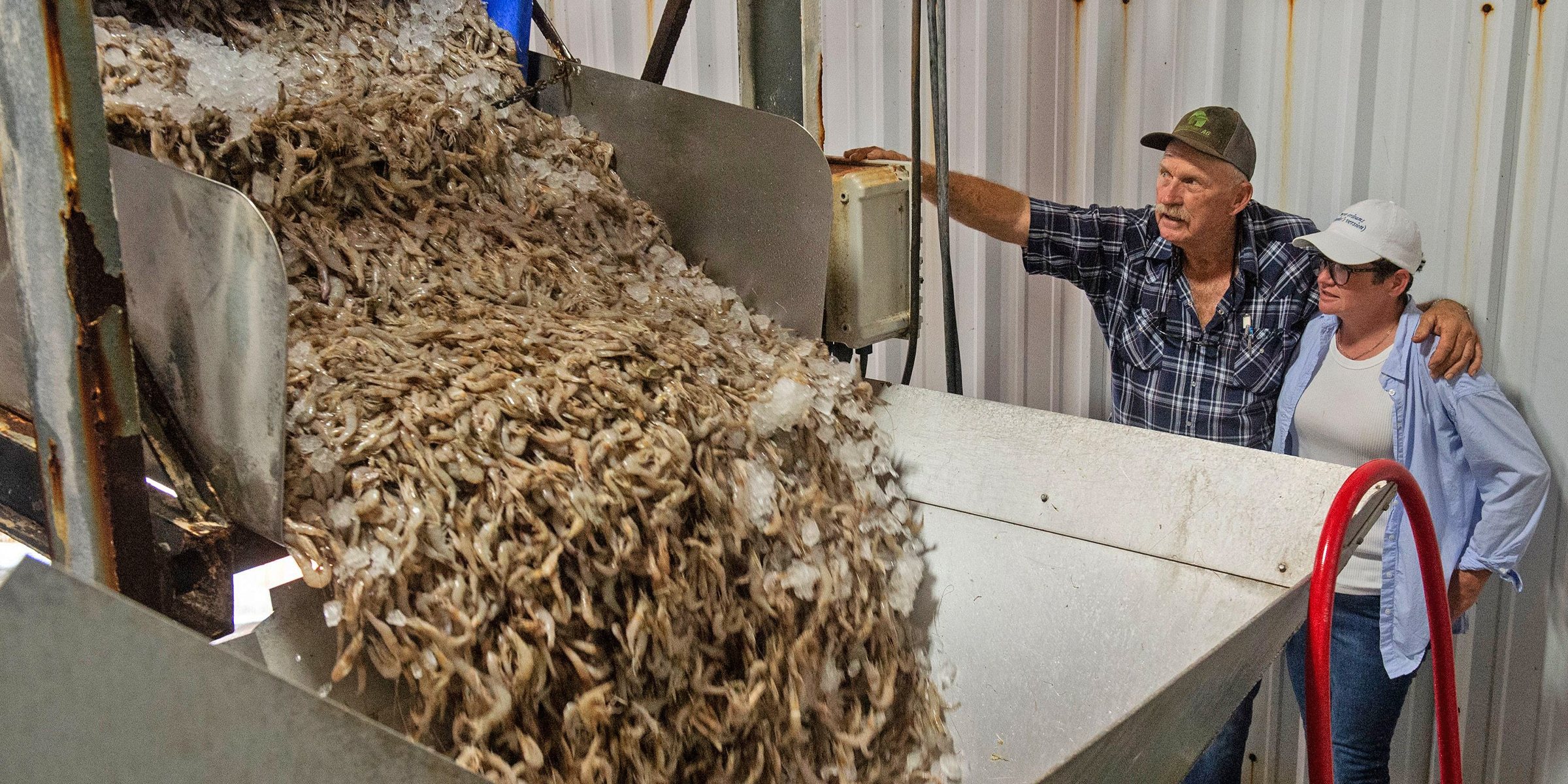 Two people standing next to a batch of shrimp. | Source: Getty Images