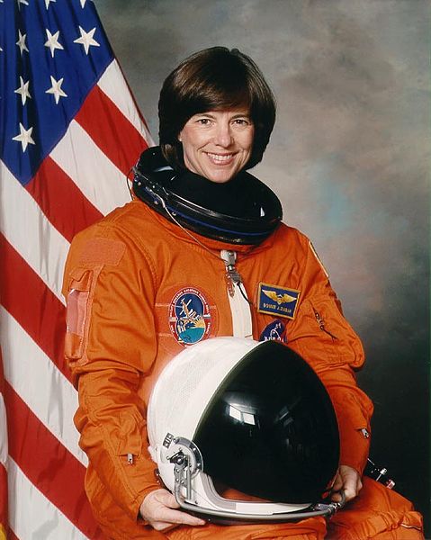 Portrait of Bonnie J. Dunbar in NASA uniform with U.S. flag in the background | Source: Wikimedia Commons
