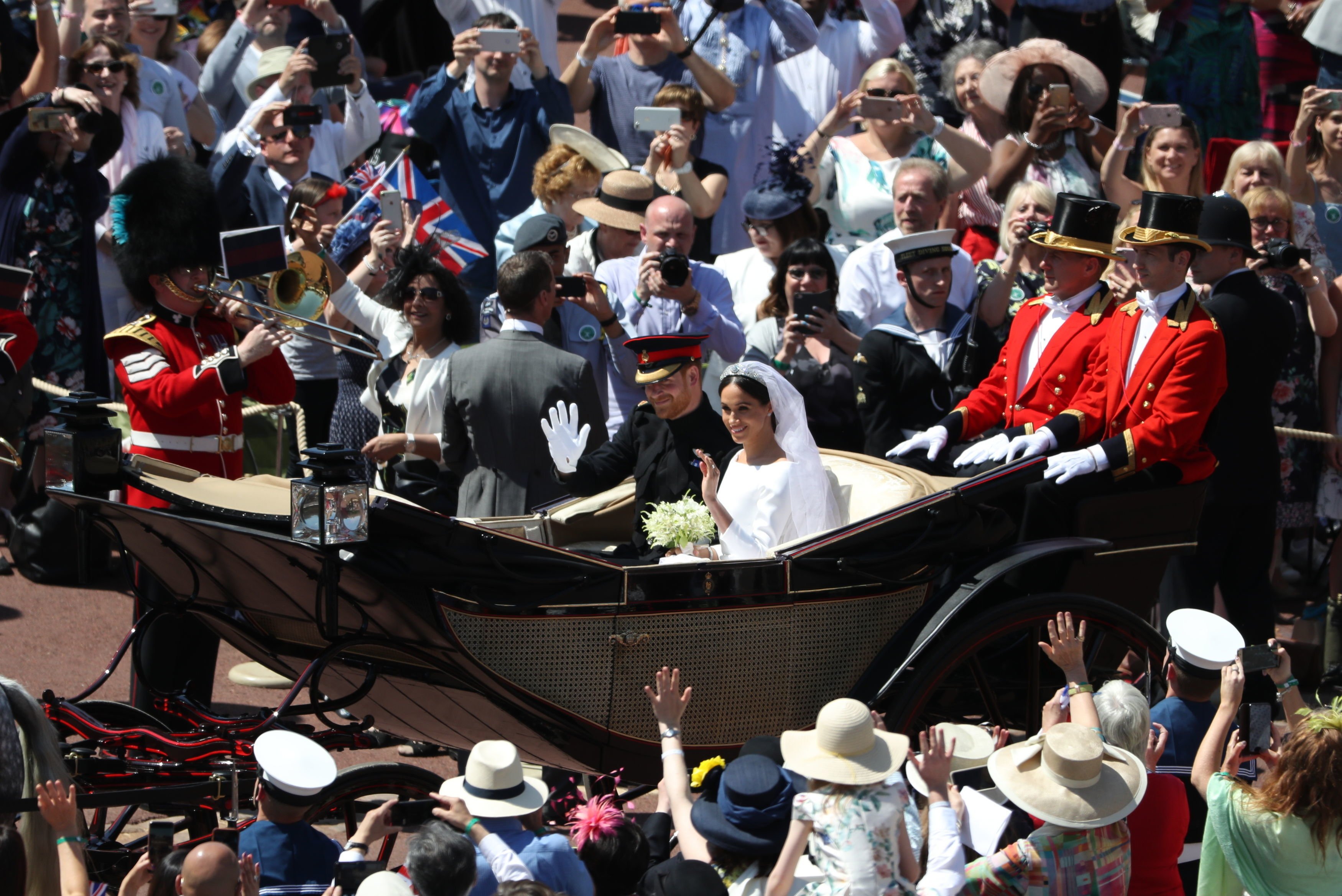 Crowds cheer for newlyweds, Prince Harry and Meghan Markle in the Ascot Landau carriage on May 19, 2018 in Windsor, England. | Source: Getty Images 