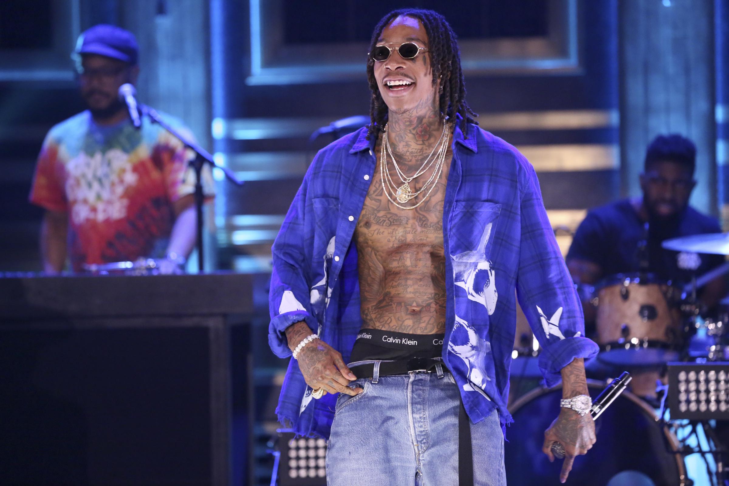 Wiz Khalifa showcased his noticeably bulked-up physique while performing "Hopeless Romantic" with Swae Lee on an episode of "The Tonight Show Starring Jimmy Fallon" taped on July 18, 2018. With his shirt unbuttoned and tattoos on full display, the rapper's muscular frame reflected the results of the MMA training that had become a major part of his lifestyle.