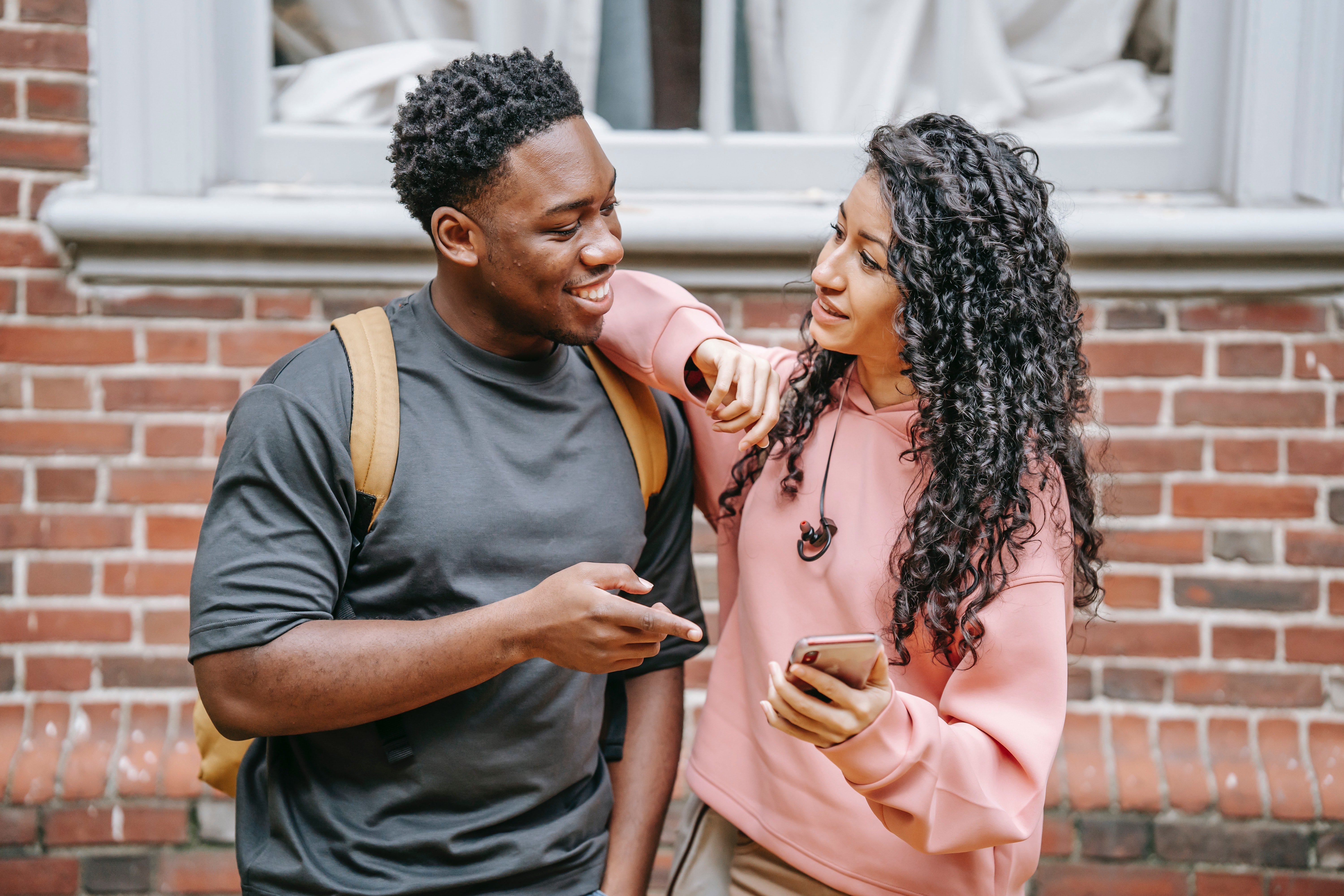 A teenage boy and girl smiling at each other | Source: Pexel/ Keira Burton