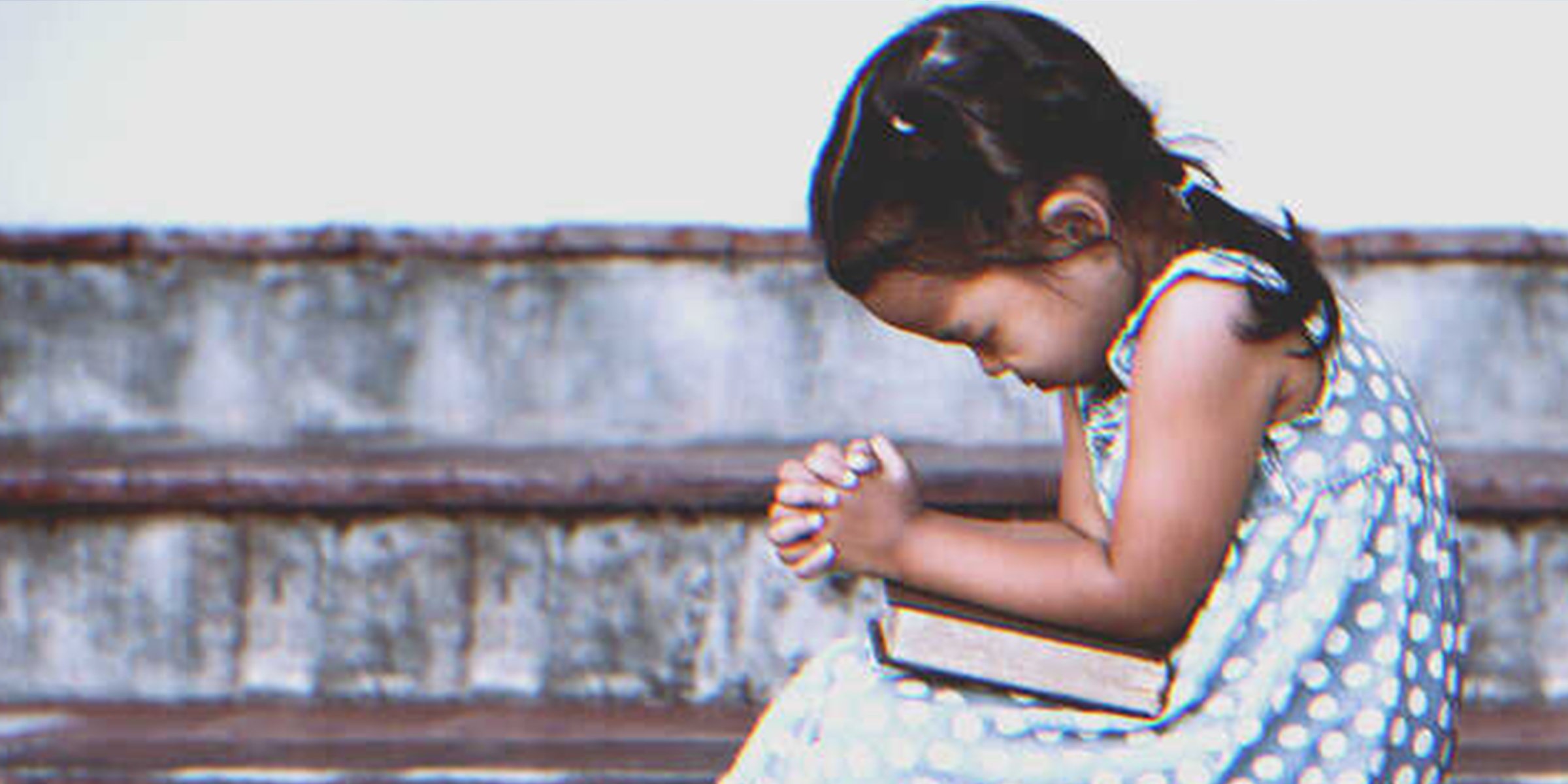 Une petite fille en train de prier | Shutterstock   