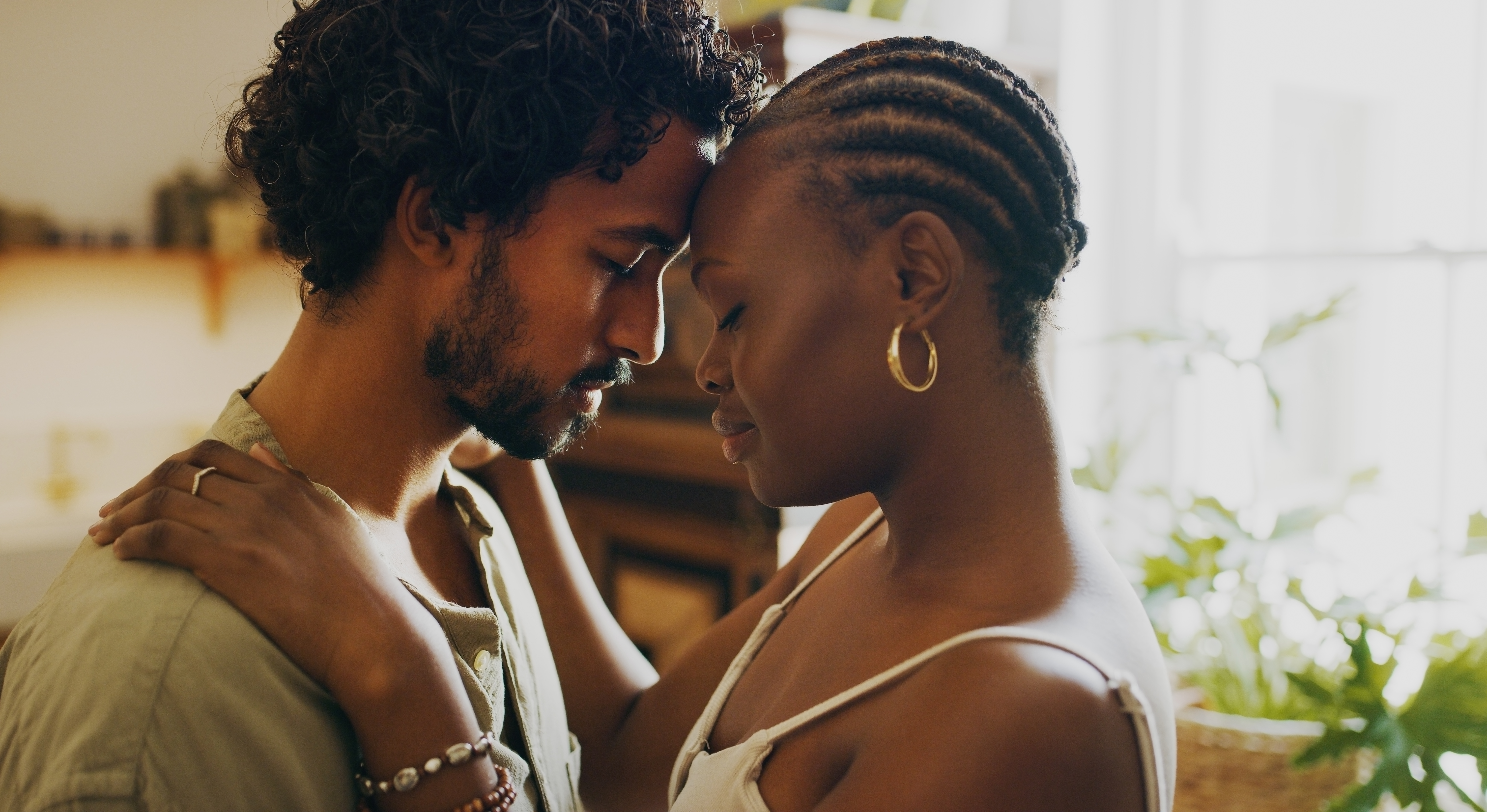 Shot of a young couple standing together and sharing an intimate moment at home | Source: Getty Images