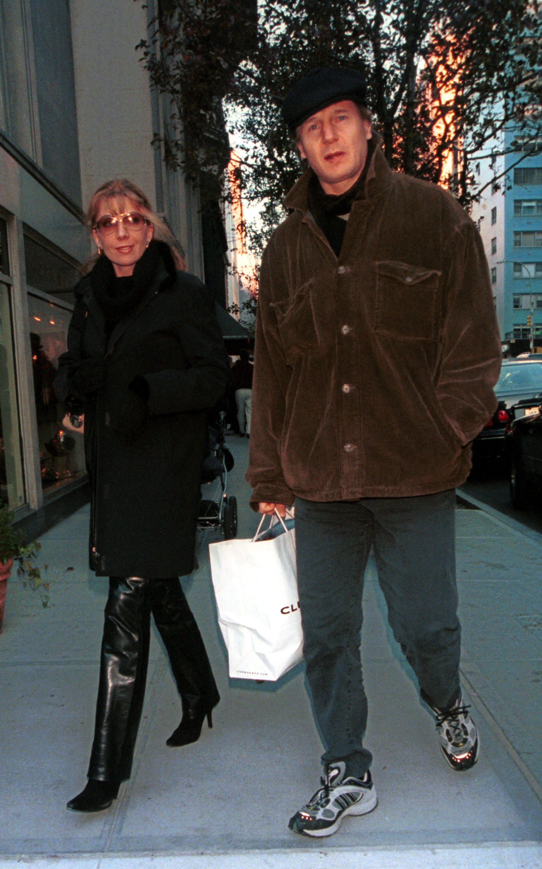 Natasha Richardson and Liam Neeson walk together along Madison Avenue in New York City on December 2, 2000. Neeson carries a shopping bag as they stroll side by side during their outing.