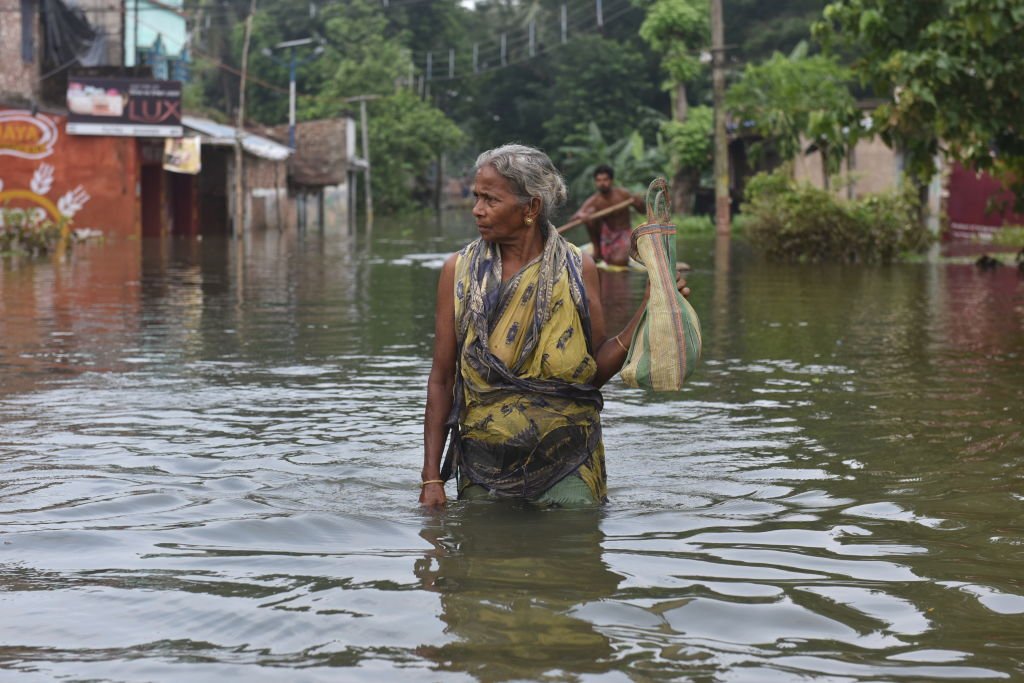 A woman wading through the flooded water in West Bangal. August 6, 2021 | Source: Getty Images