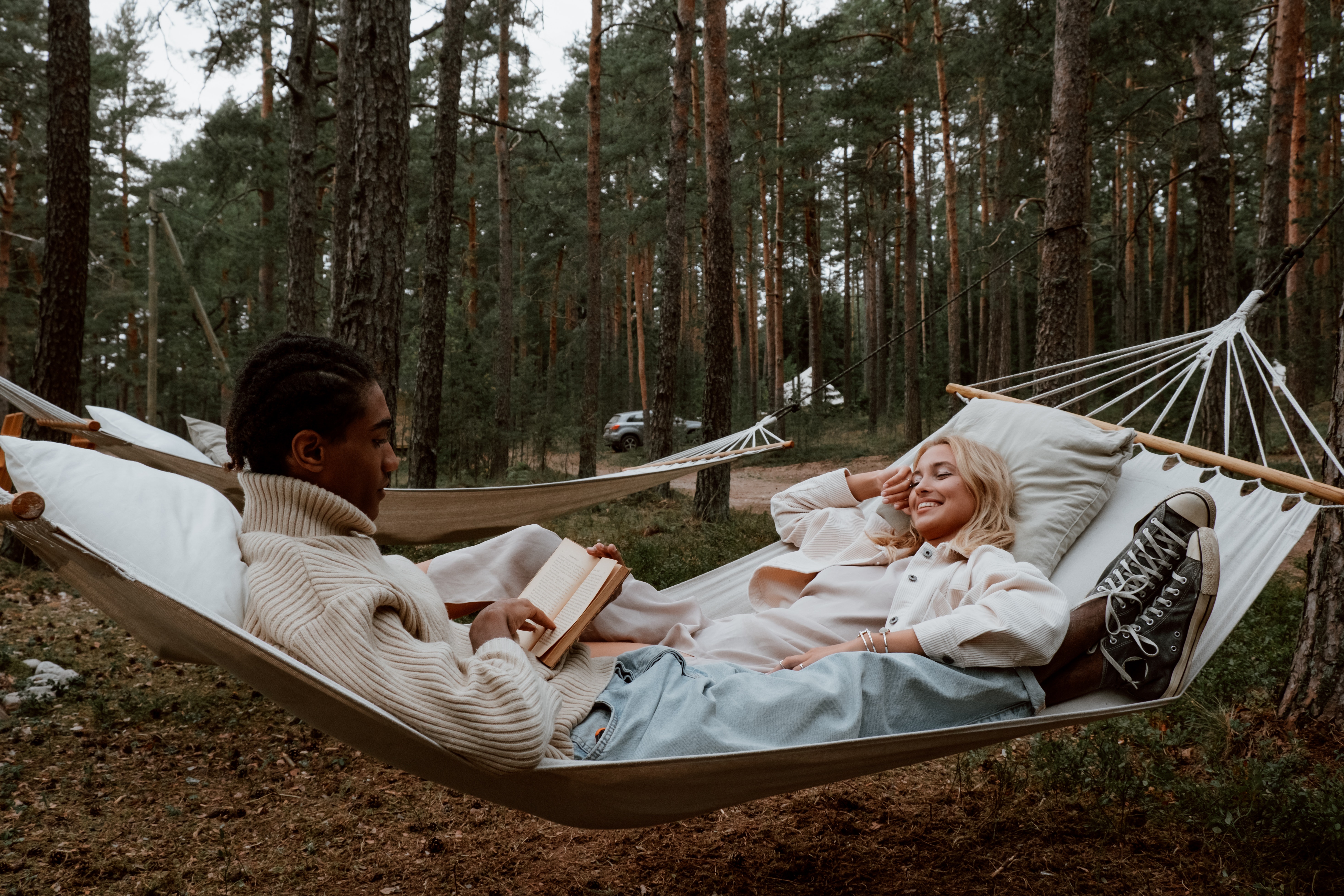 A man and a woman lounging in the middle of the woods. | Source: Pexels