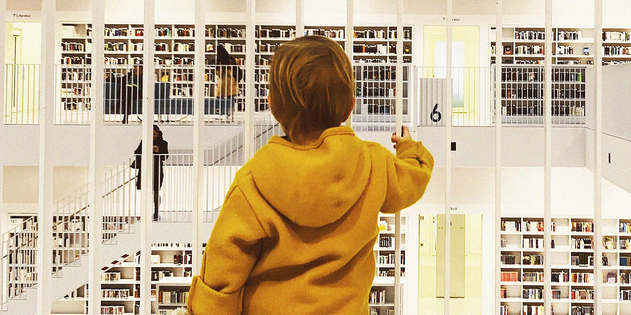 Unsplash | A child looking through bars in a library 