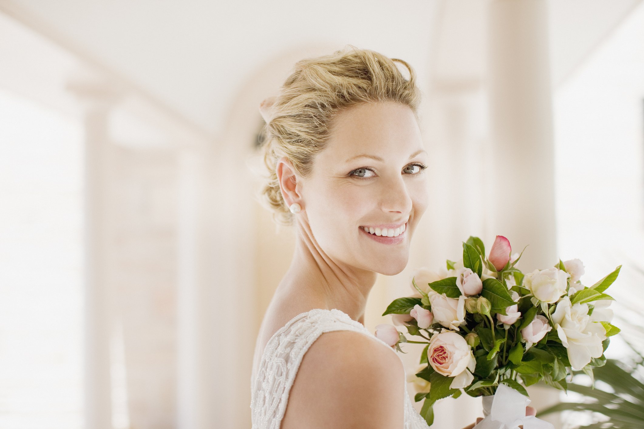 Braut, die mit einem Blumenstrauß lächelt. | Quelle: Getty Images