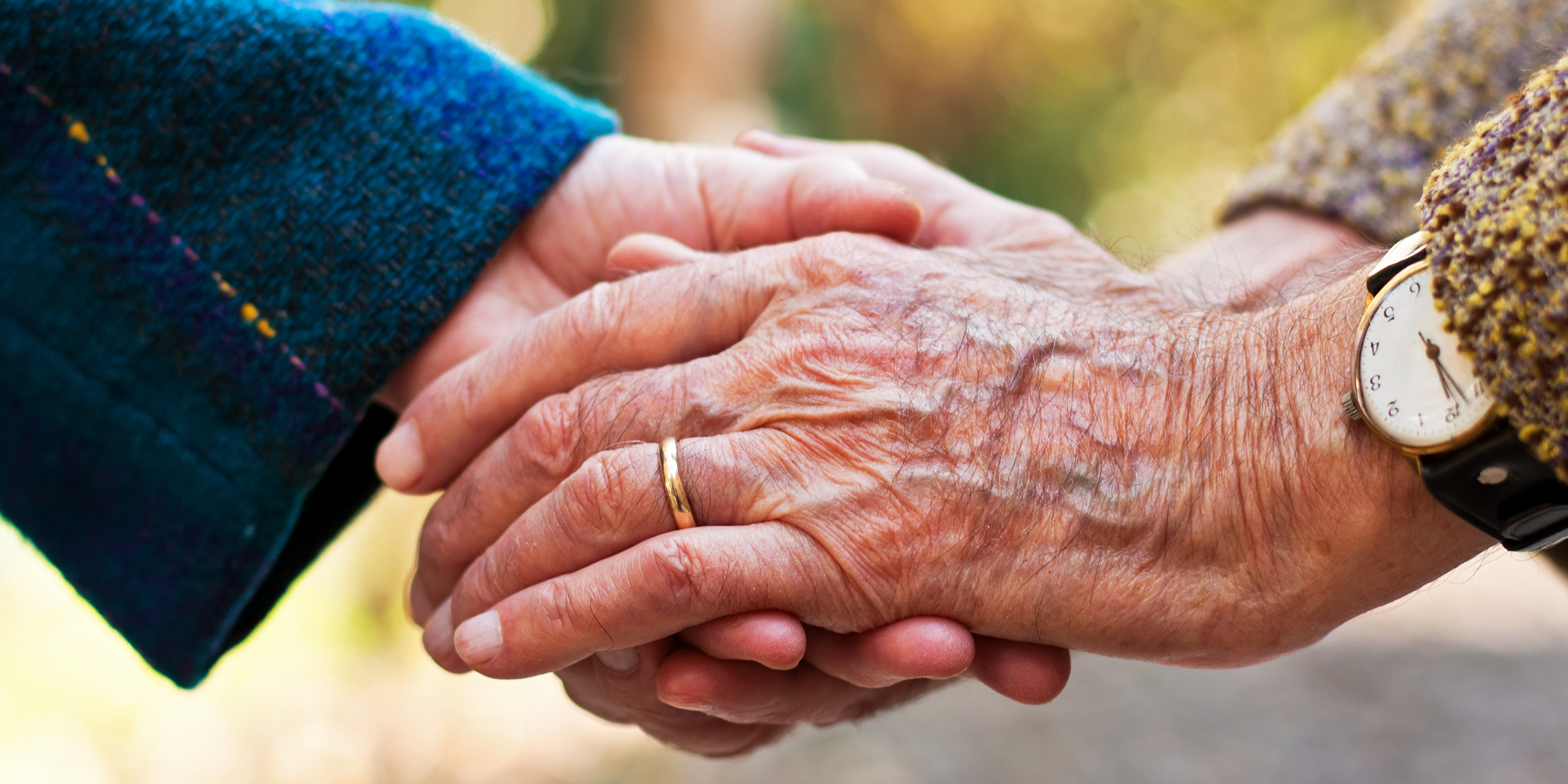 Elderly people holding hands | Source: Shutterstock