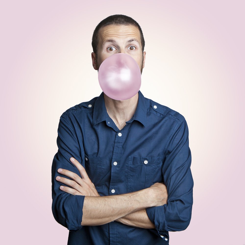 Un homme faisant une bulle avec son chewing gum. | Photo : Shutterstock