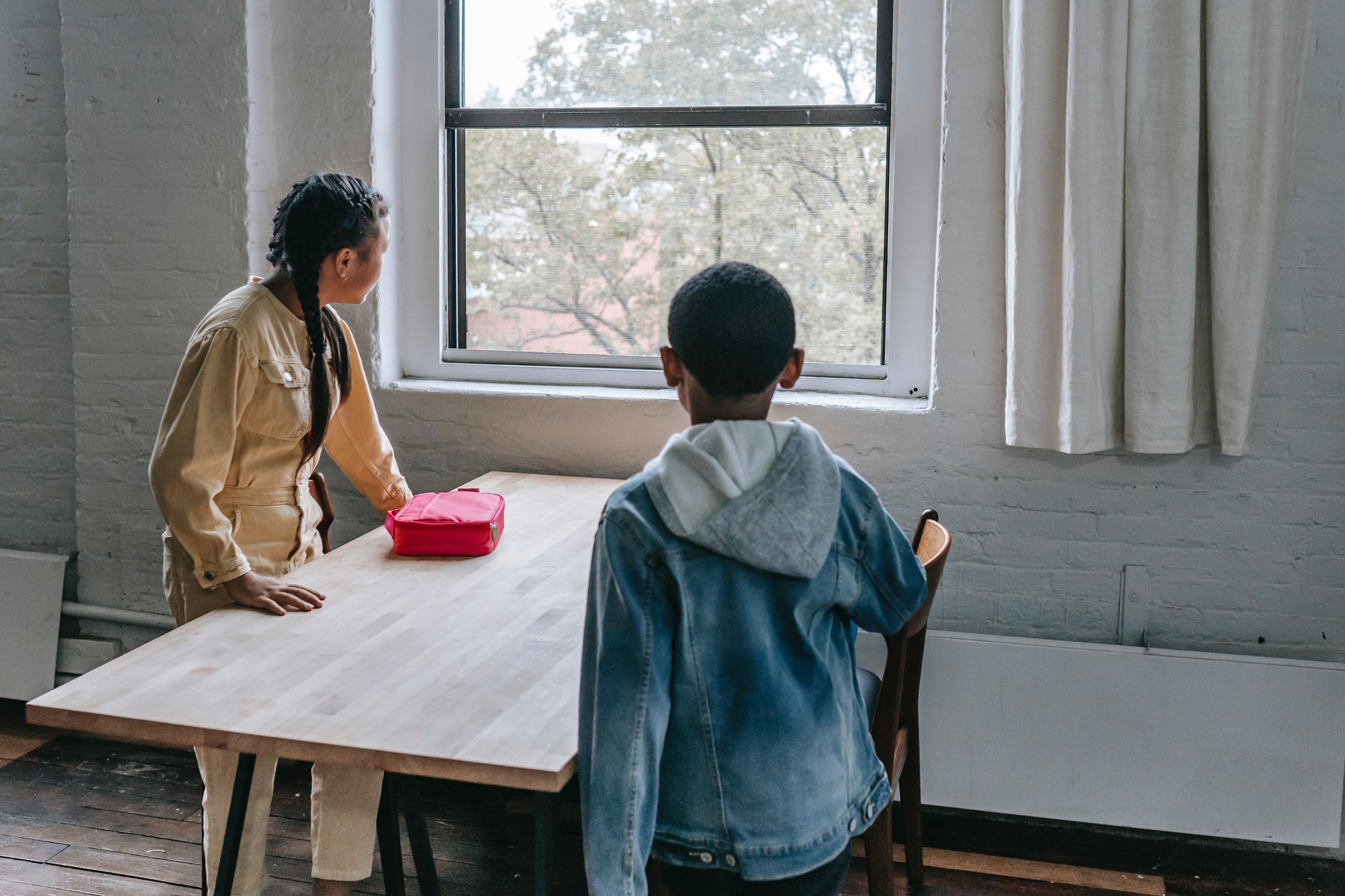 Two children looking out the window | Source: Pexels