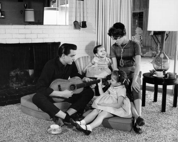 Country singer/songwriter Johnny Cash holds a guitar as his wife Vivian Liberto and daughters, Rosanne Cash and Kathy Cash look on in 1957 | Photo: Getty Images