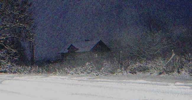 A distant house covered in snow | Source: Shutterstock