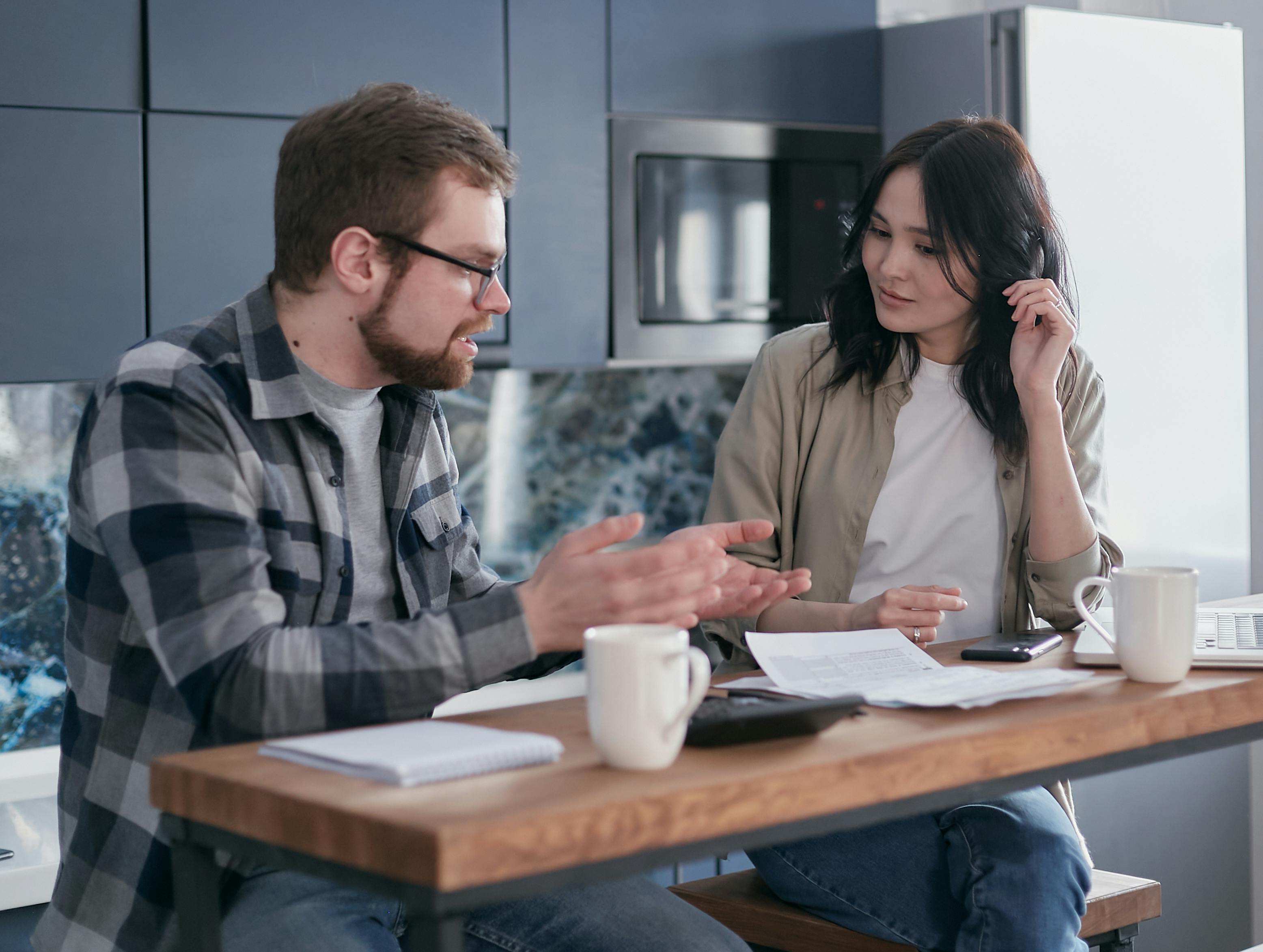 Man gesturing to a woman listening to him | Source: Pexels