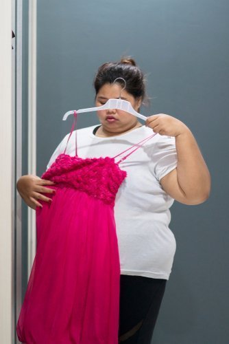Mollige Frau probiert Kleidung an | Quelle: Shutterstock