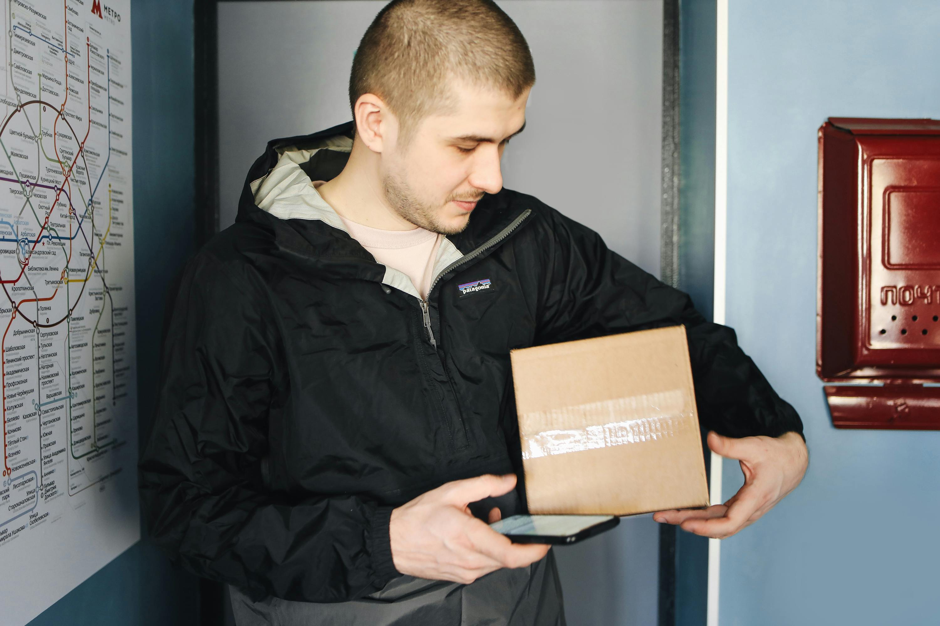 Delivery man holding a cardboard box | Source: Pexels