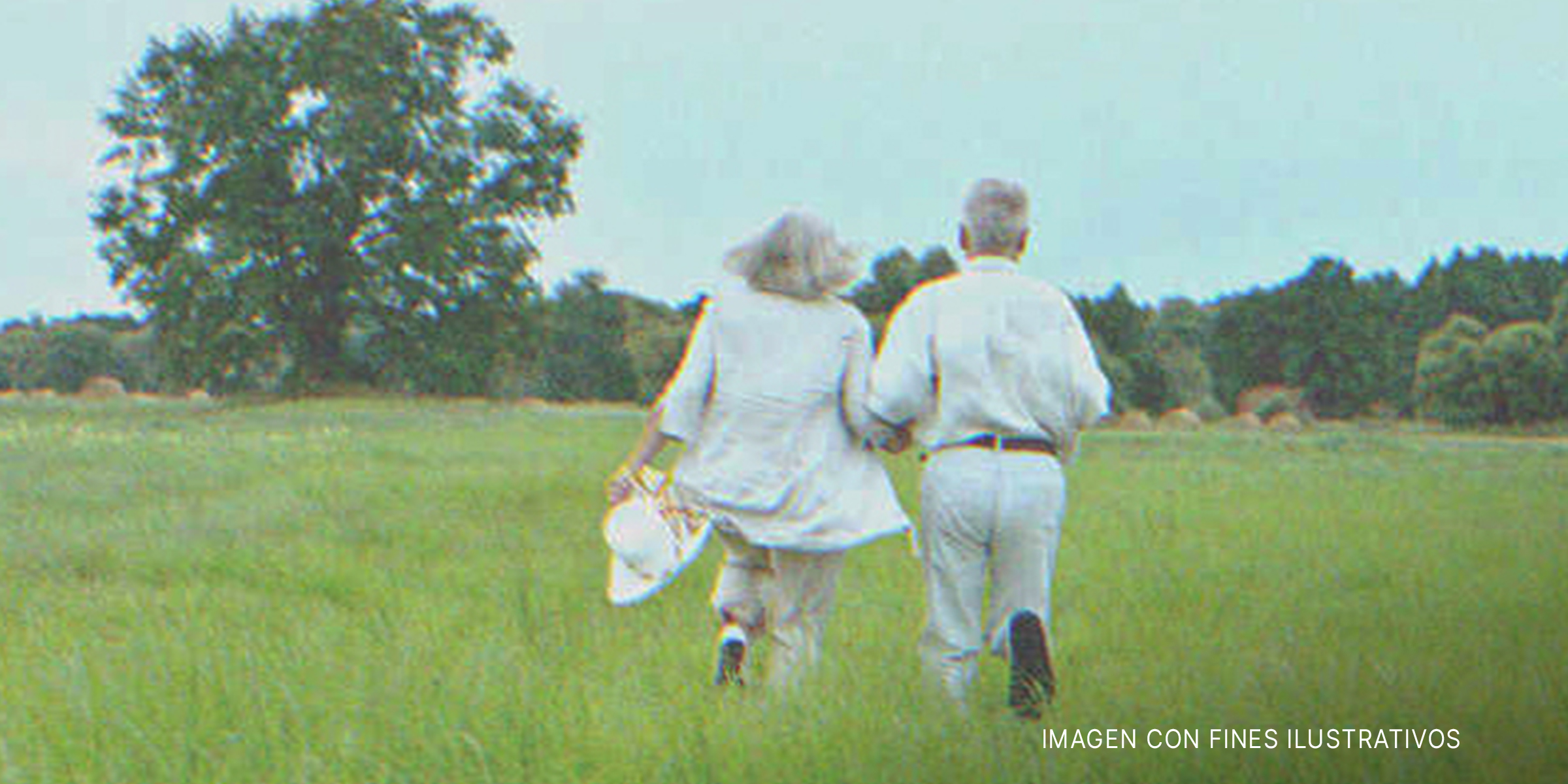 Una anciana y un anciano caminando por el pasto. | Foto: Shutterstock