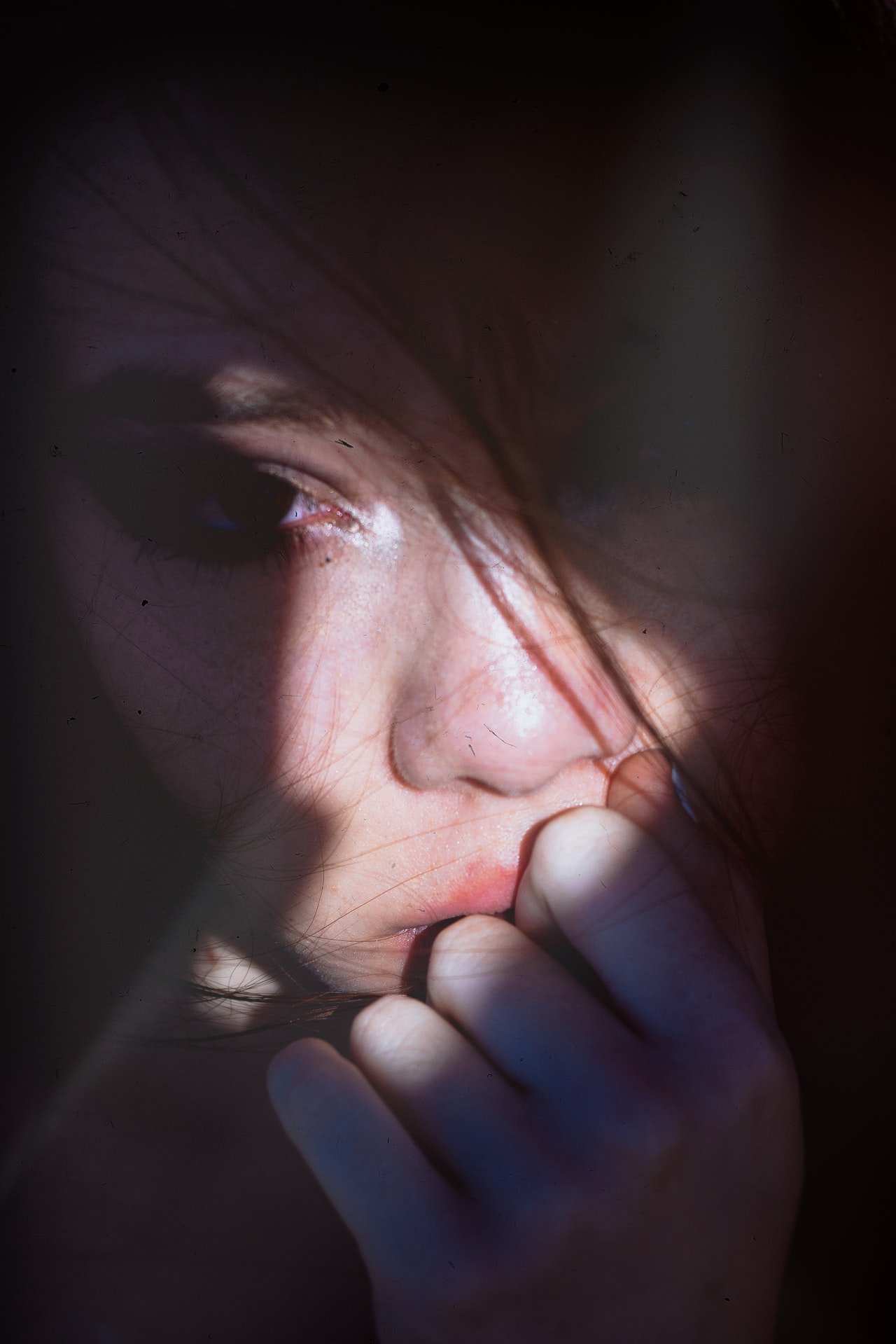 Una joven con su mano sobre su boca y rostro asustado. | Foto: Pexels