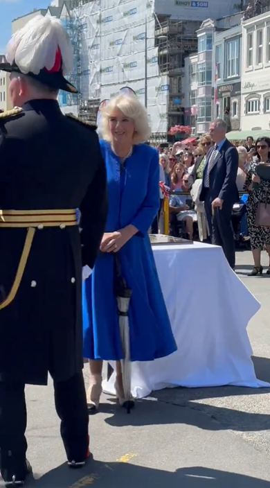 Queen Camilla is seen walking with an umbrella during her and King Charles III's visit to Guernsey, posted in July 2024. | Source: x.com/RE_DailyMail