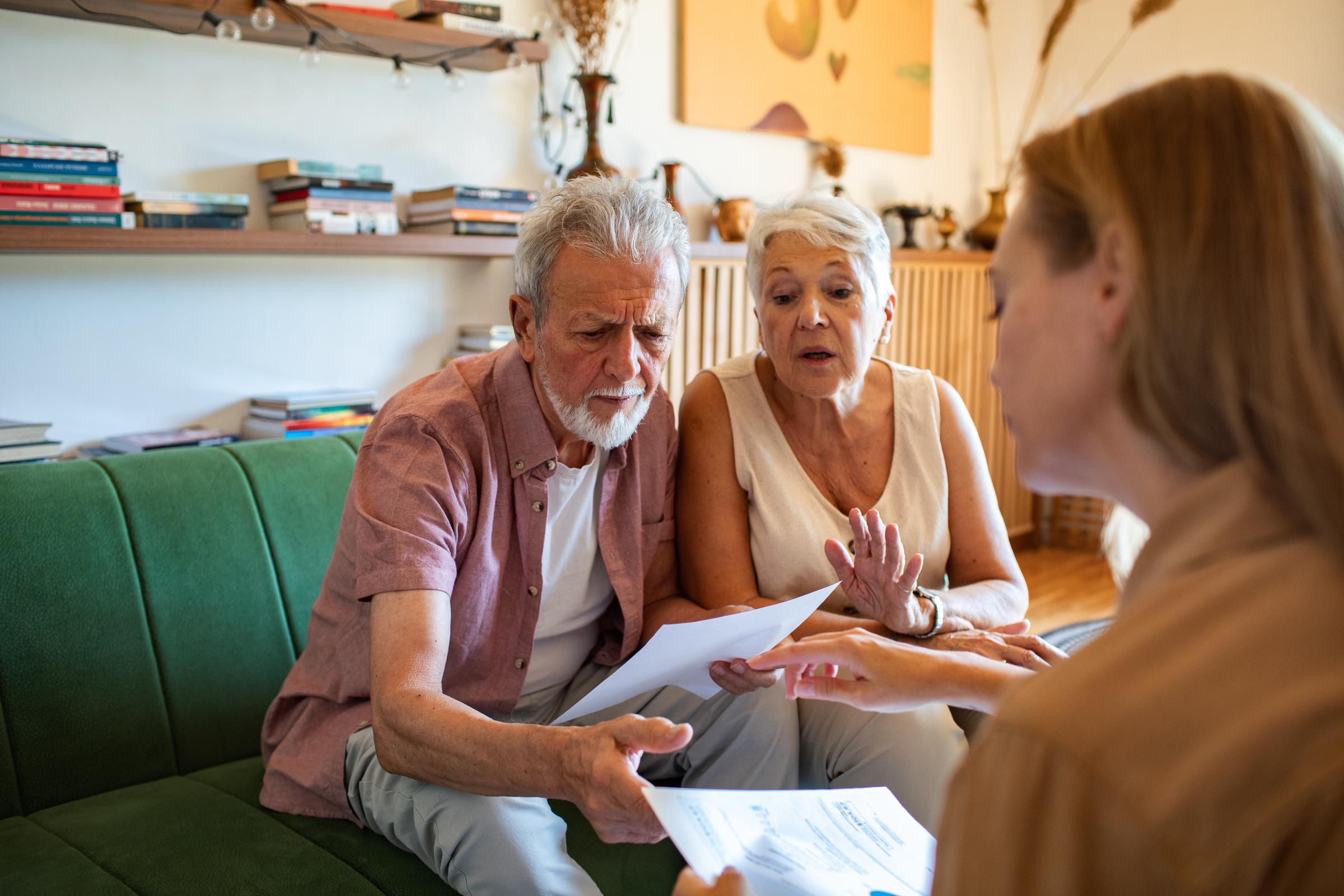 Senior couple looking over documents with a woman | Source: Shutterstock