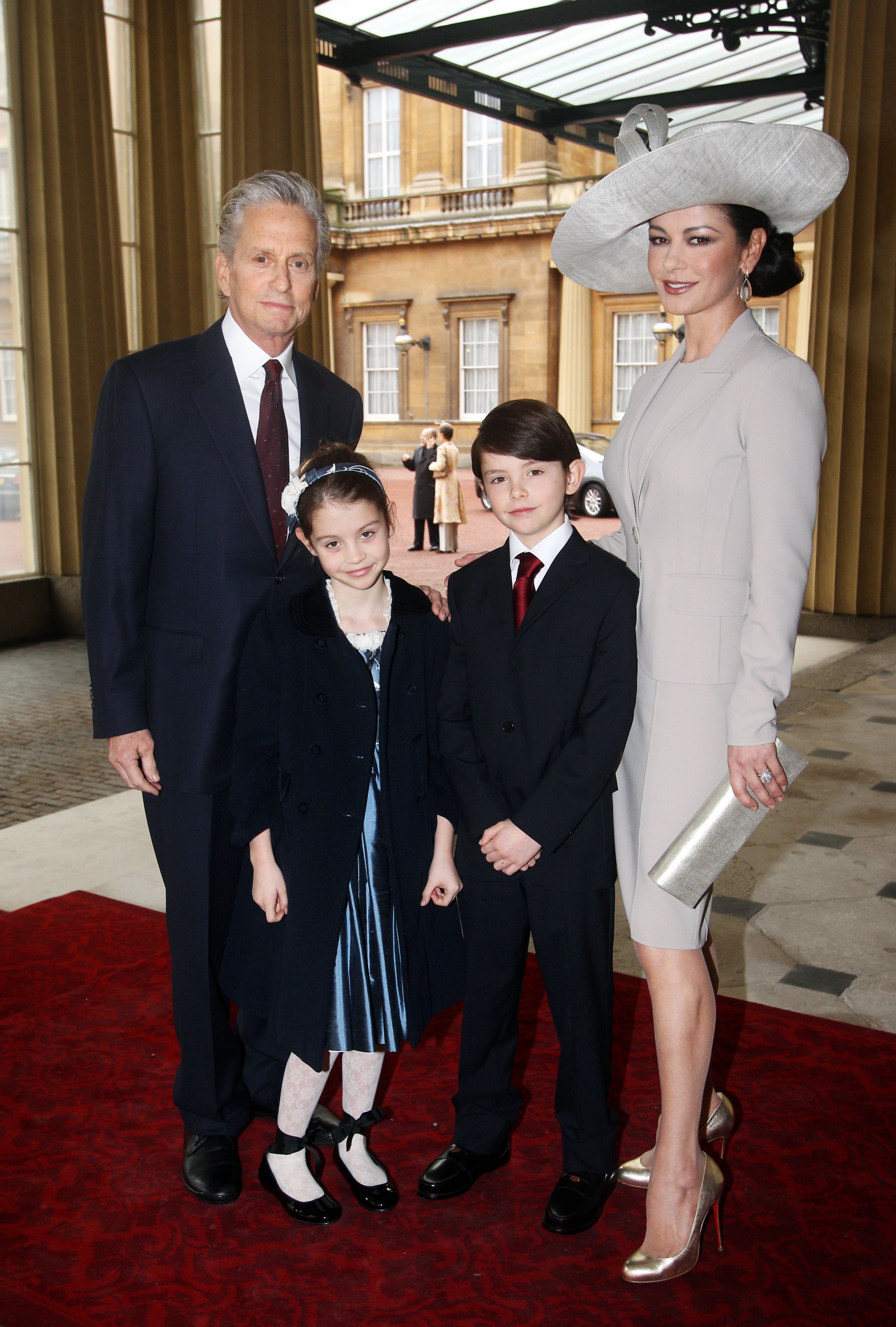 Catherine Zeta-Jones arrives with her husband, Michael Douglas and their children Dylan and Carys Douglas, to attend a Royal Investiture at Buckingham Palace on February 24, 2011 in London, England | Source: Getty Images