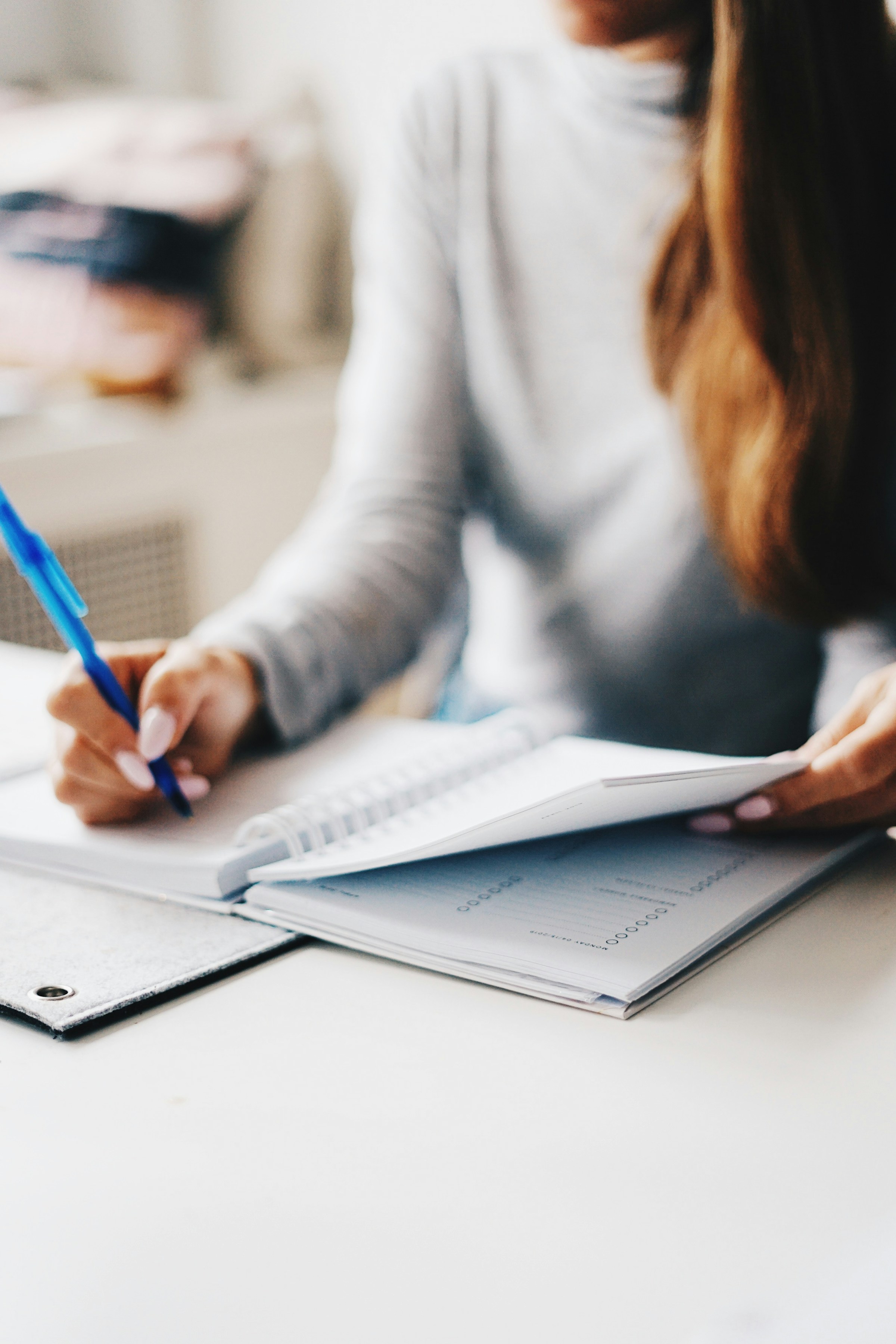 A woman writing in a notebook | Source: Unsplash