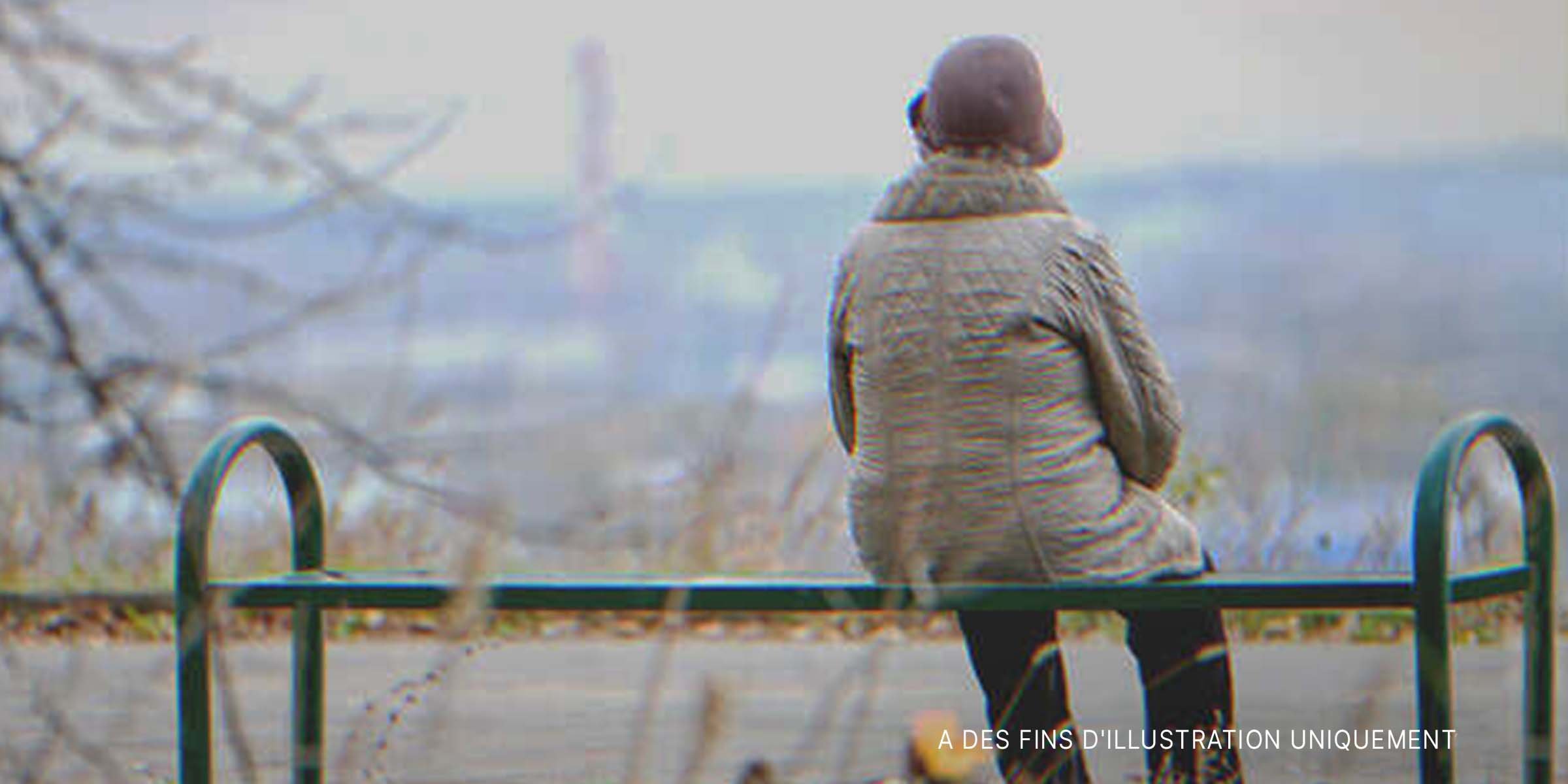 Vieille femme assise sur un banc. | Shutterstock