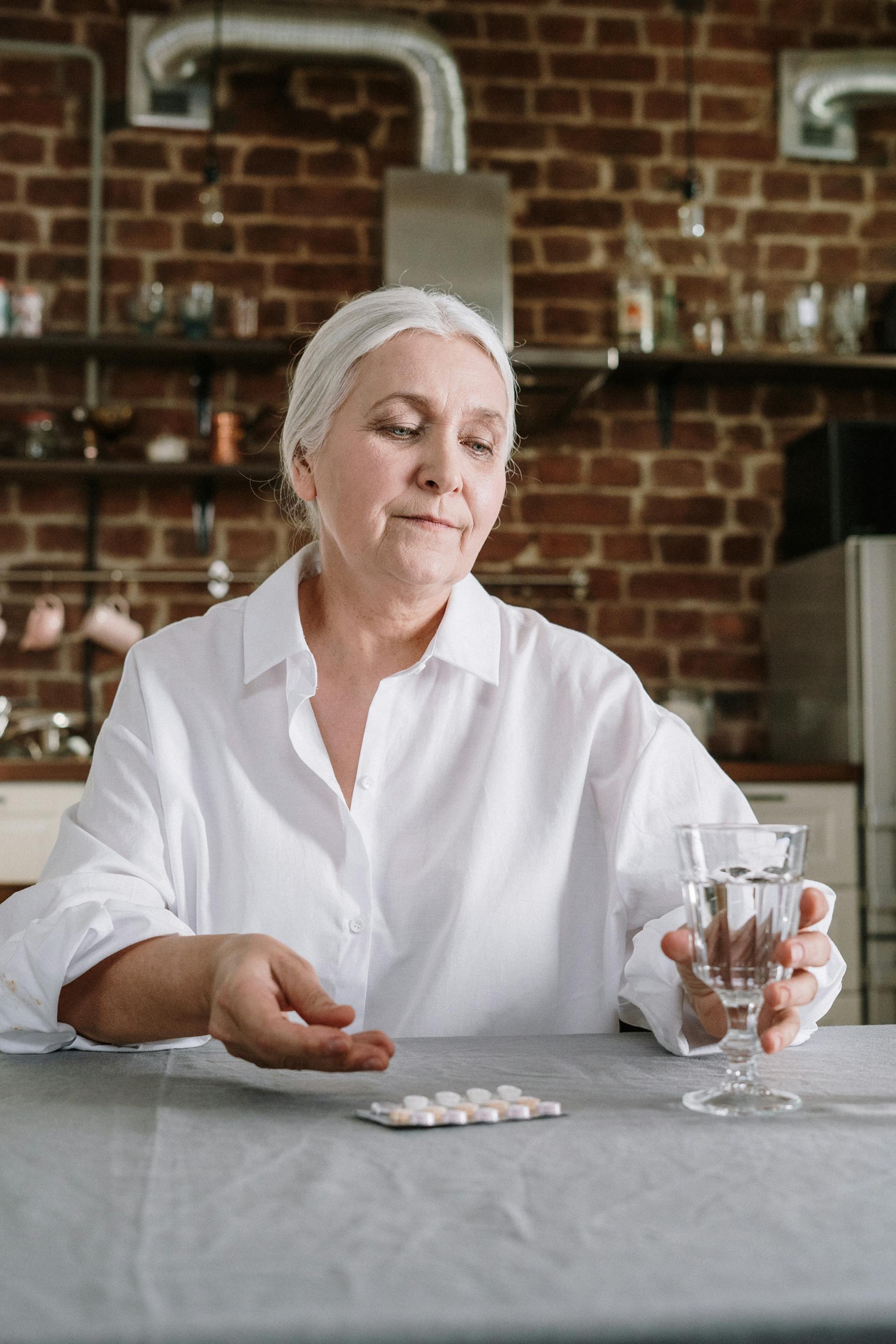 An old woman holding a glass of water | Source: Pexels