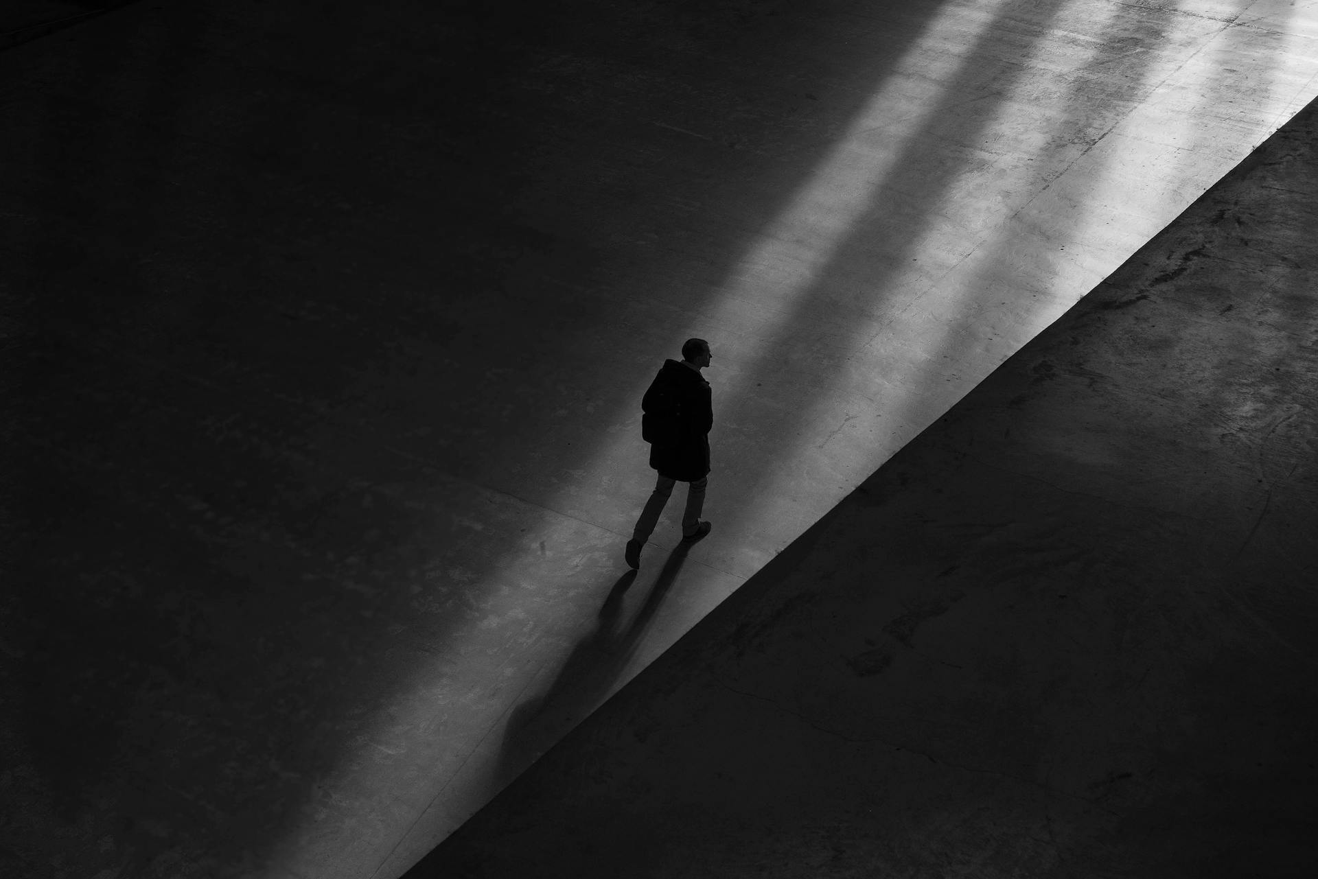 Grayscale silhouette of a man walking away | Source: Pexels