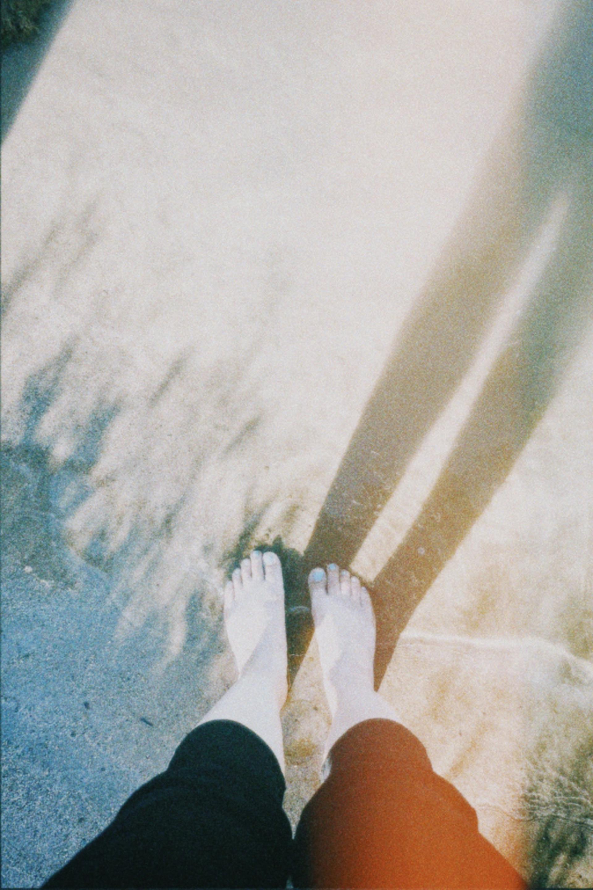 Woman standing barefoot on ground | Source: Pexels