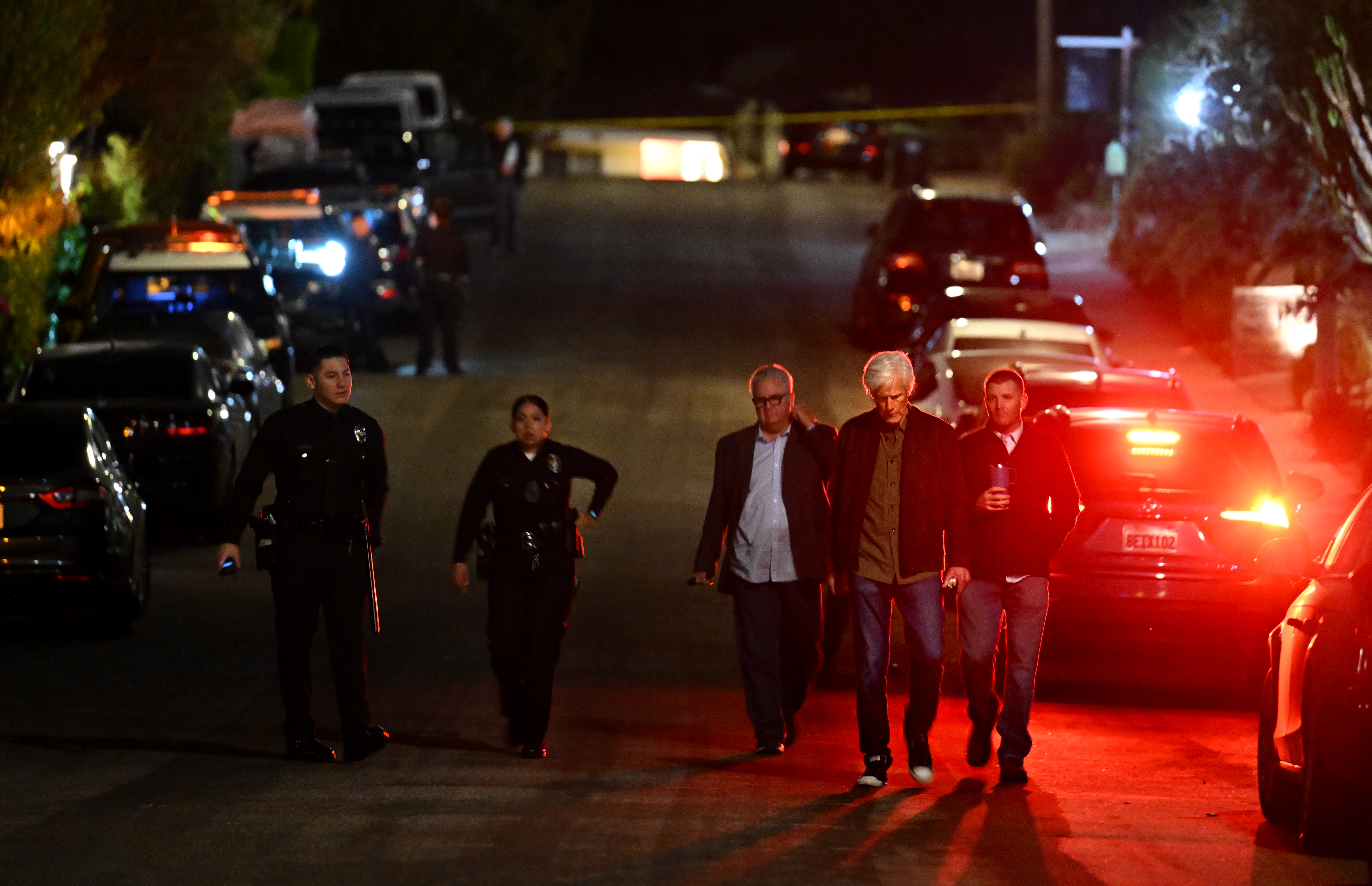 Matthew Perry's stepfather, Keith Morrison, with police investigators down the street from Perry's house in Pacific Palisades on October 28, 2023 | Source: Getty Images