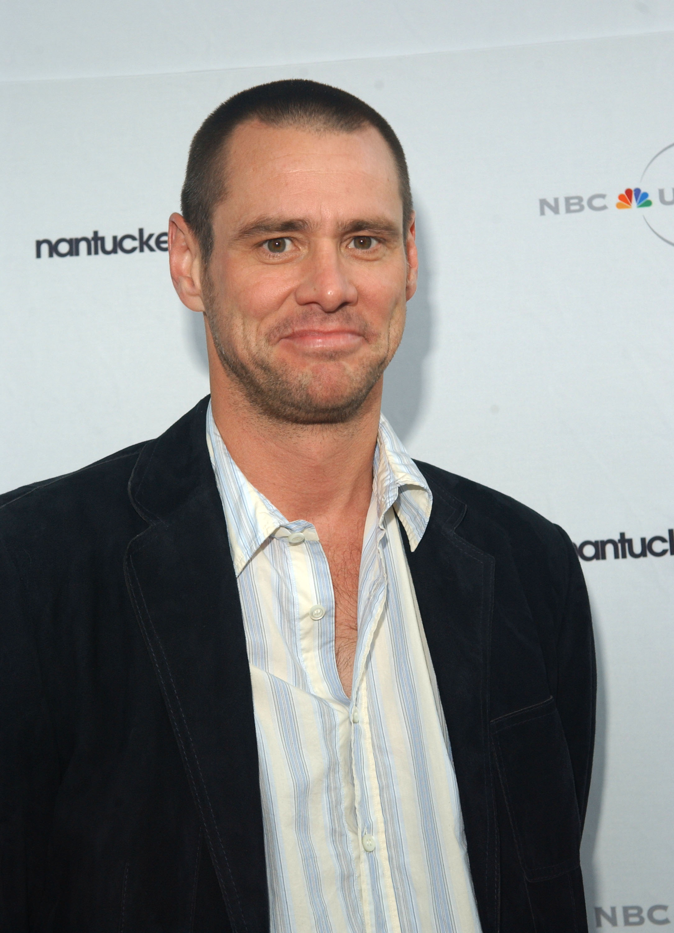 Sporting a close-cropped buzz cut, Jim Carrey flashes a funny smile in a striped open-collar shirt layered beneath a dark velvet blazer. The relaxed look adds a touch of understated ease to the Nantucket Film Festival’s NBC Screenwriters’ Tribute to Charlie Kaufman.