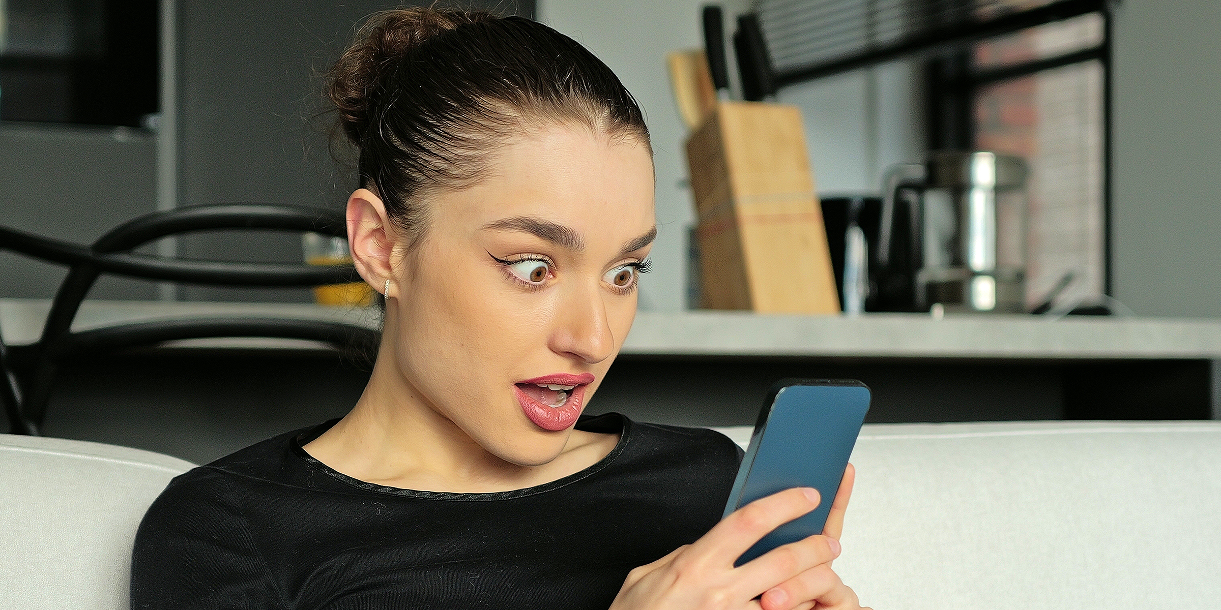 A shocked woman looking at her phone | Source: Shutterstock