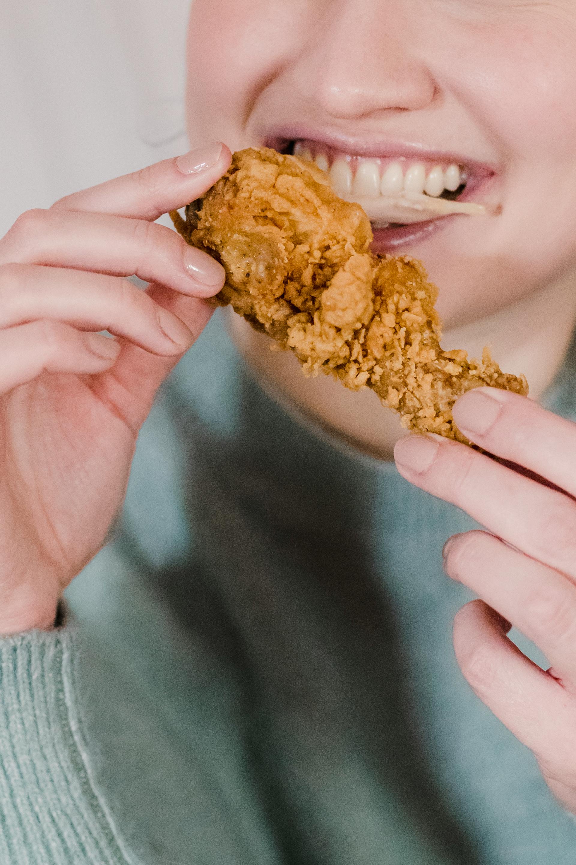 A person eating fried chicken | Source: Pexels