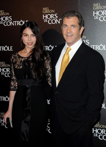 Oksana Grigorieva (L) and U.S actor Mel Gibson (R) pose as they attend the film premiere of "Edge Of Darkness" at Cinema UGC Normandie on February 4, 2010, in Paris, France. | Source: Getty Images.