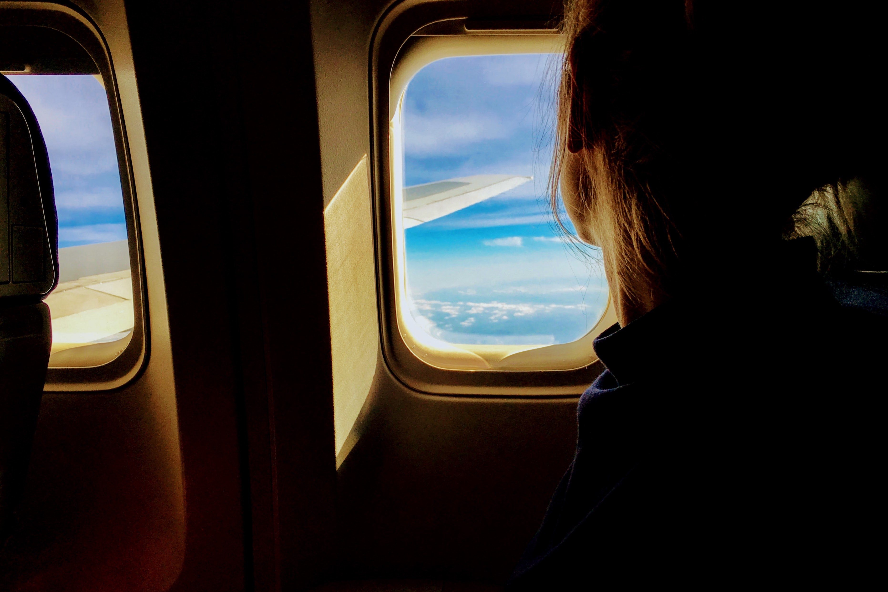 Blonde woman looking out of a plane window. | Source: Pexels/Tim Gouw