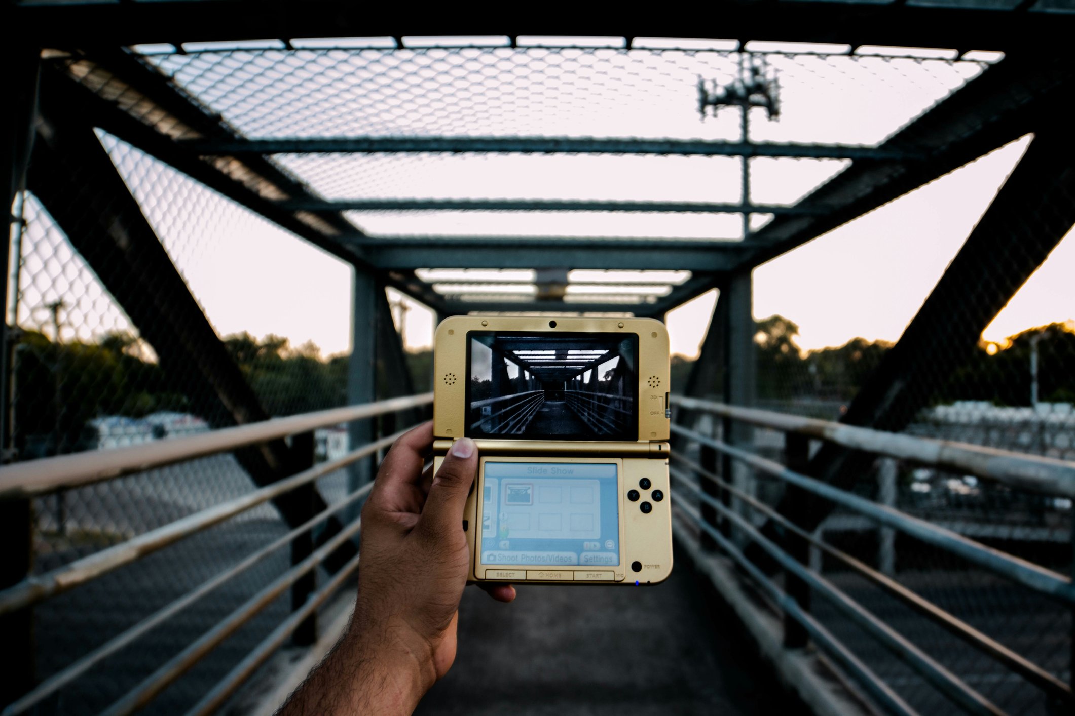 A Man Photographed holding a Nintendo 3Ds on a bridge. | Photo: Getty Images