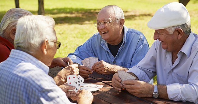 Ältere Erwachsene spielen Karten im Freien. | Quelle: Shutterstock
