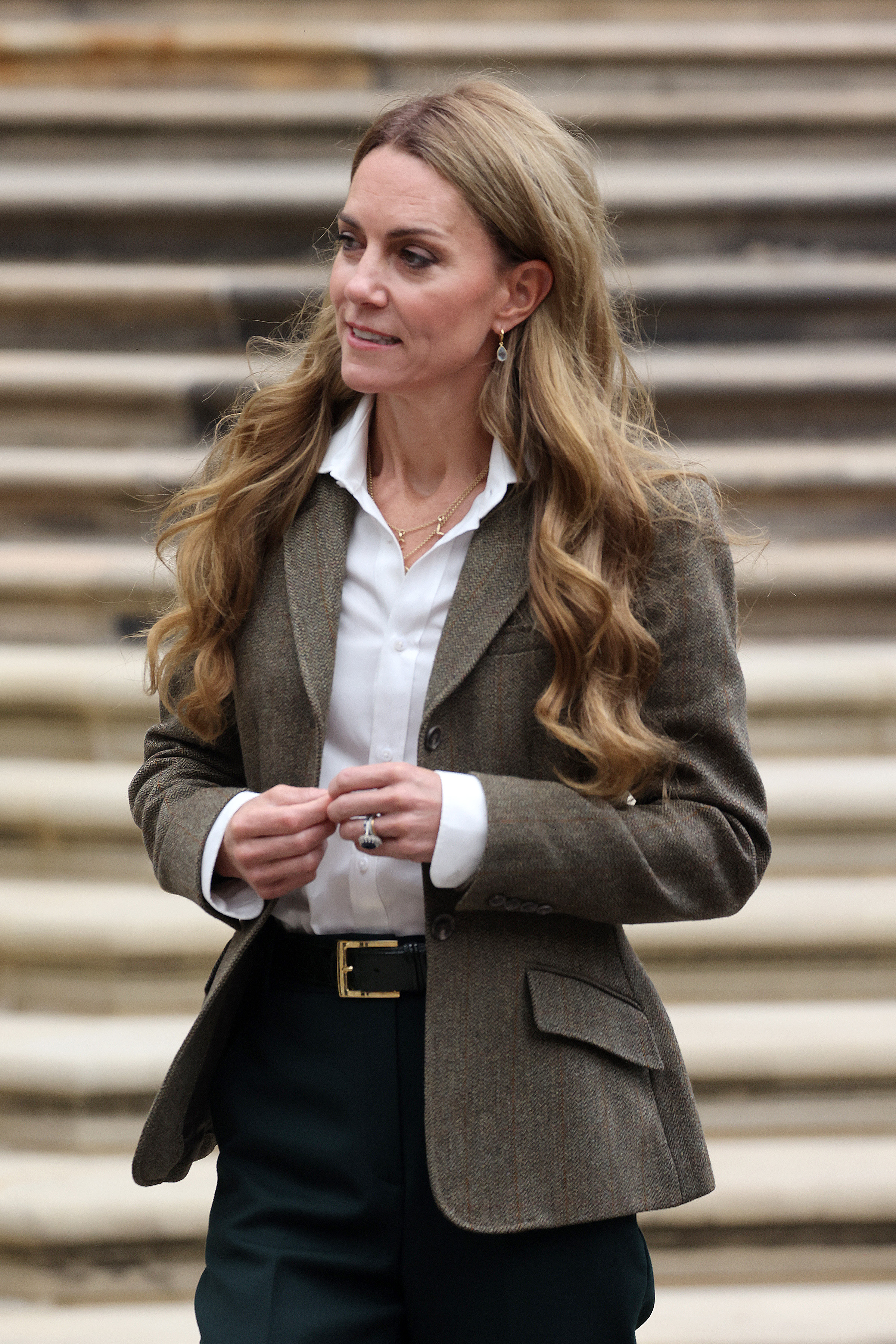 Princess Catherine, seen during her September 4, 2025 visit to the Natural History Museum, wears her hair in soft honey-blonde curls with a deep side part. Her olive-green blazer and crisp, white blouse complete the polished, early autumn look.