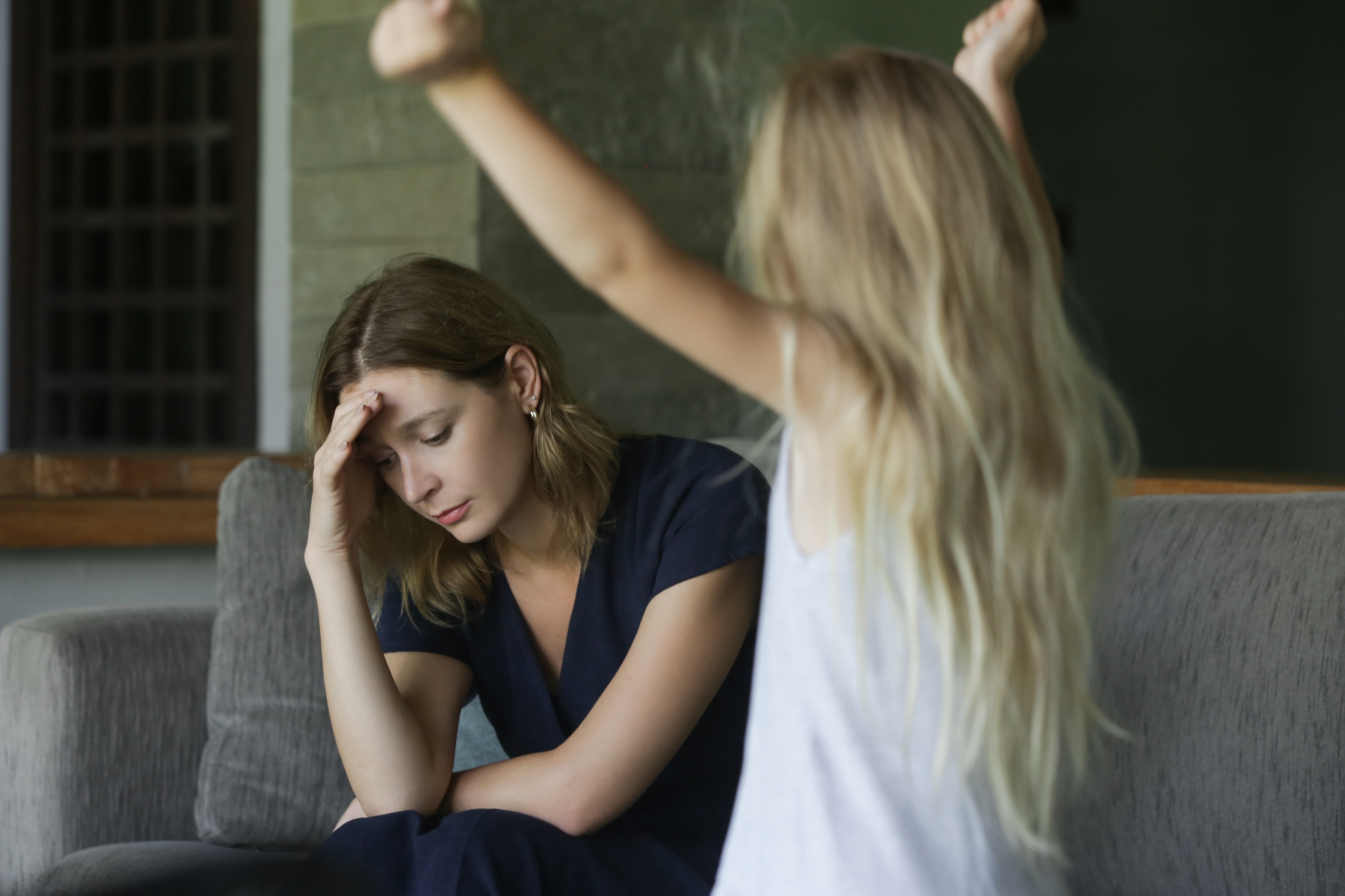 A young girl throwing a tantrum in front of her tired mom | Source: Shutterstock
