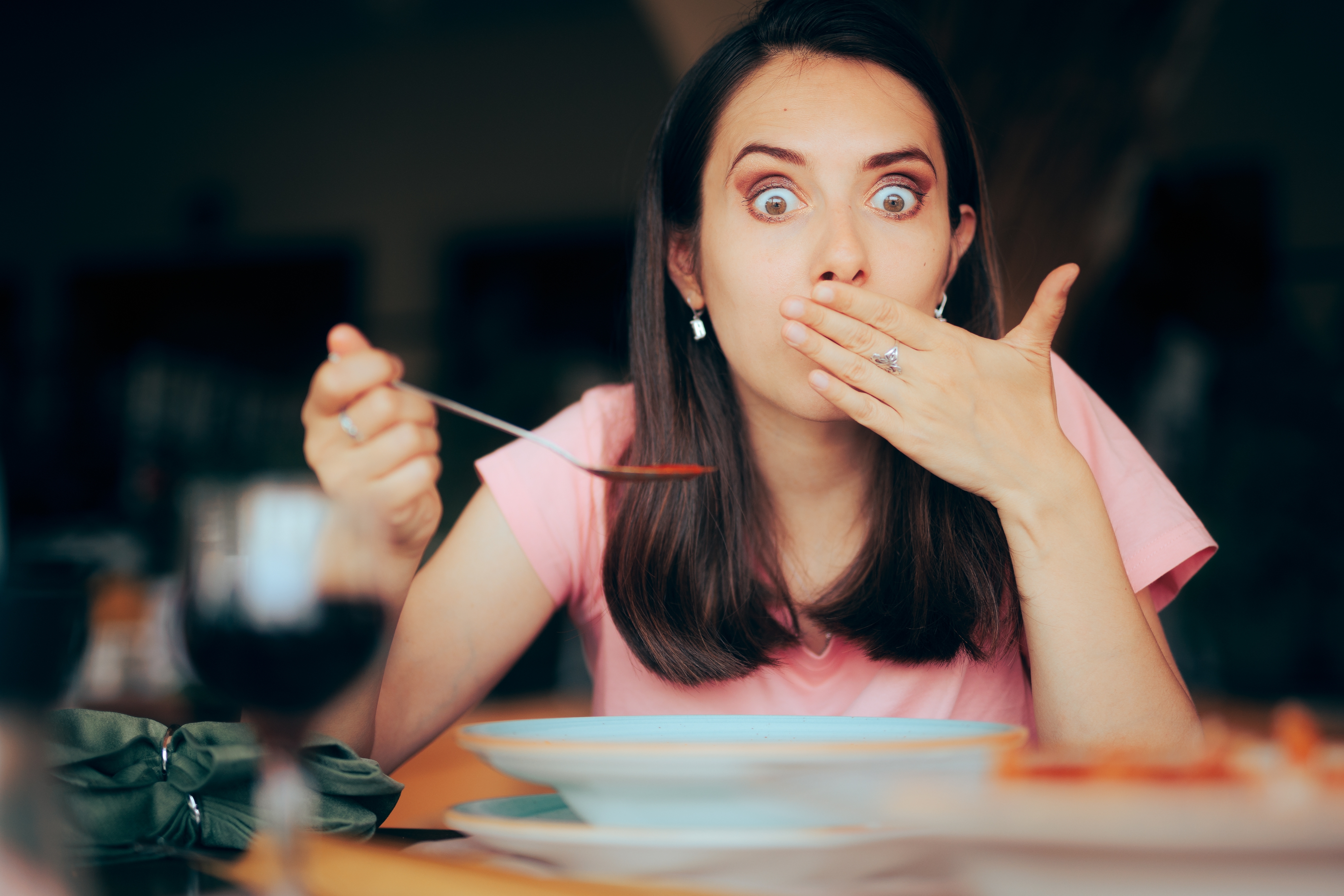 A woman covers her mouth after eating food | Source: Shutterstock