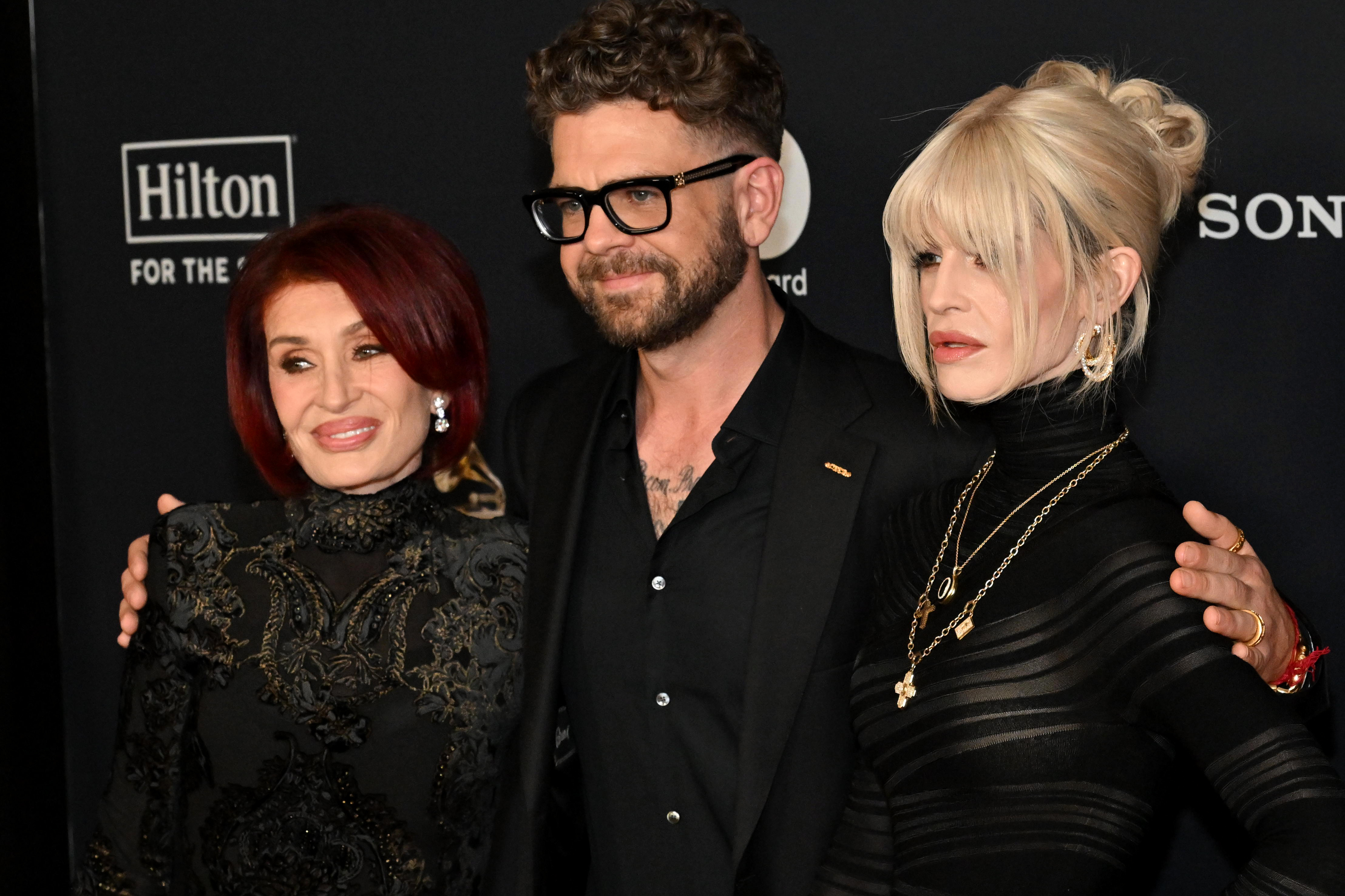 Sharon, Jack, and Kelly Osbourne pose together on the red carpet at Clive Davis' pre-Grammy gala in Los Angeles on January 31, 2026. Dressed in coordinated black looks, the family appears composed as they step out publicly ahead of the Grammy Awards, marking one of their first high-profile appearances since the death of Ozzy Osbourne.
