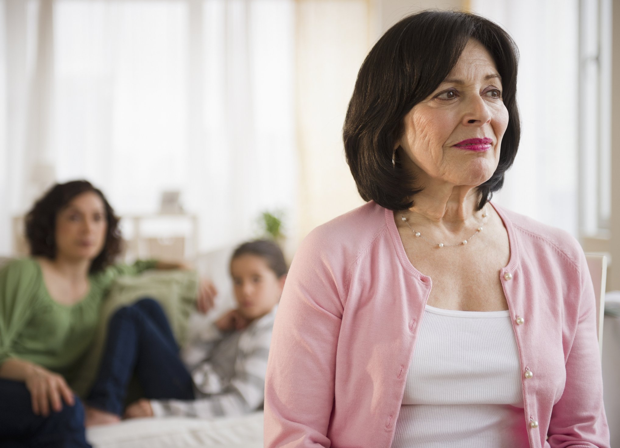 Old woman with family in background | Photo: Getty Images