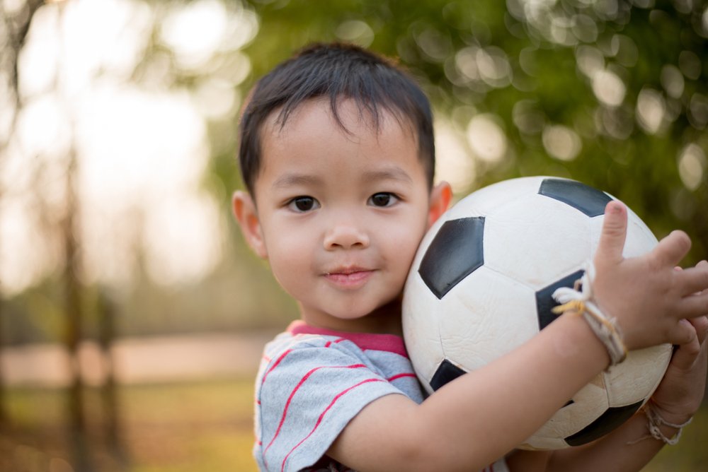 Niño feliz jugando fútbol en el parque. | Foto: Shutterstock